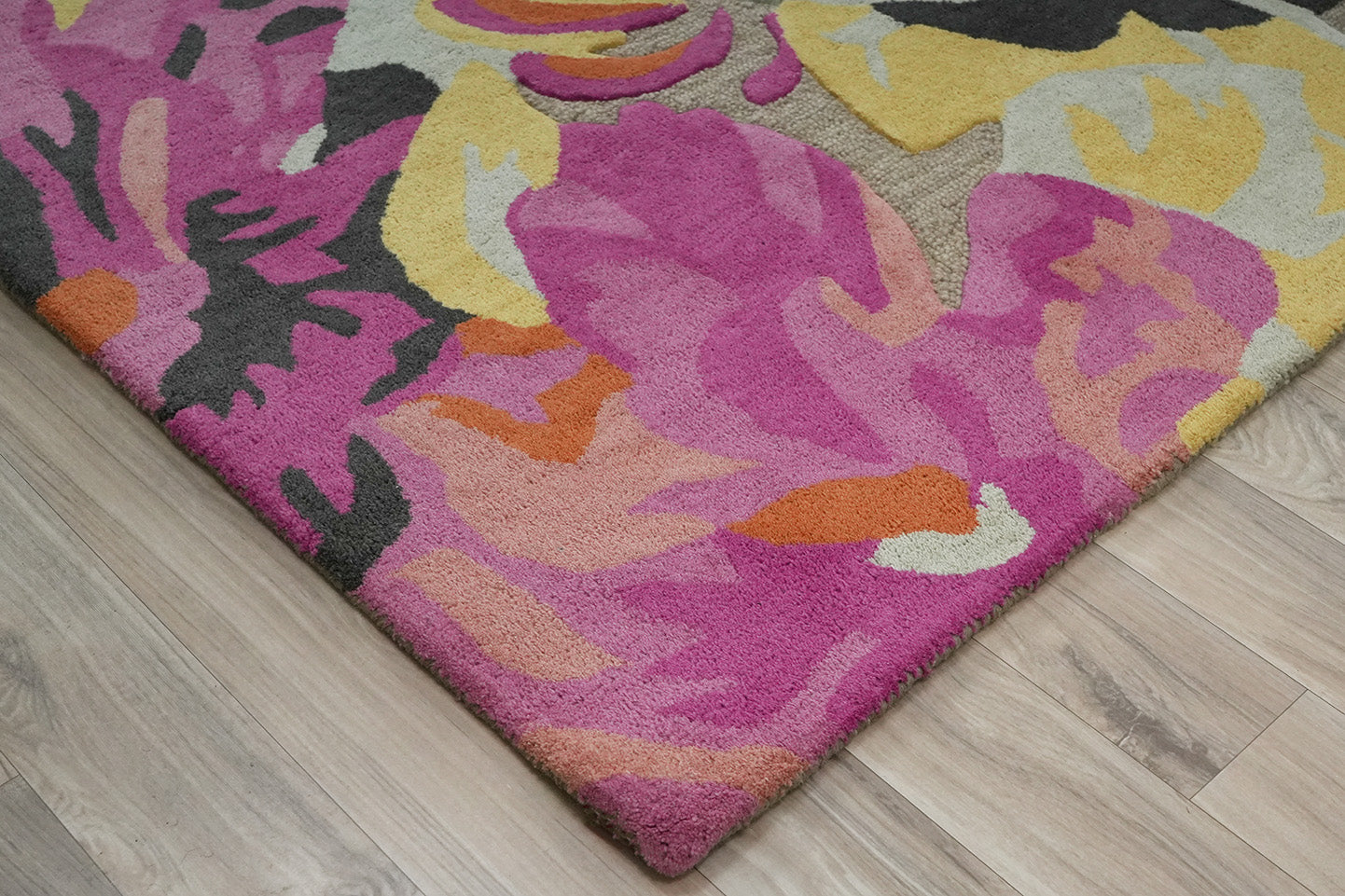 Bloomscape Floral Wool Rug made from 100 % New Zealand wool with hand tufted construction shown in close up detailing textured pile and painterly floral elements