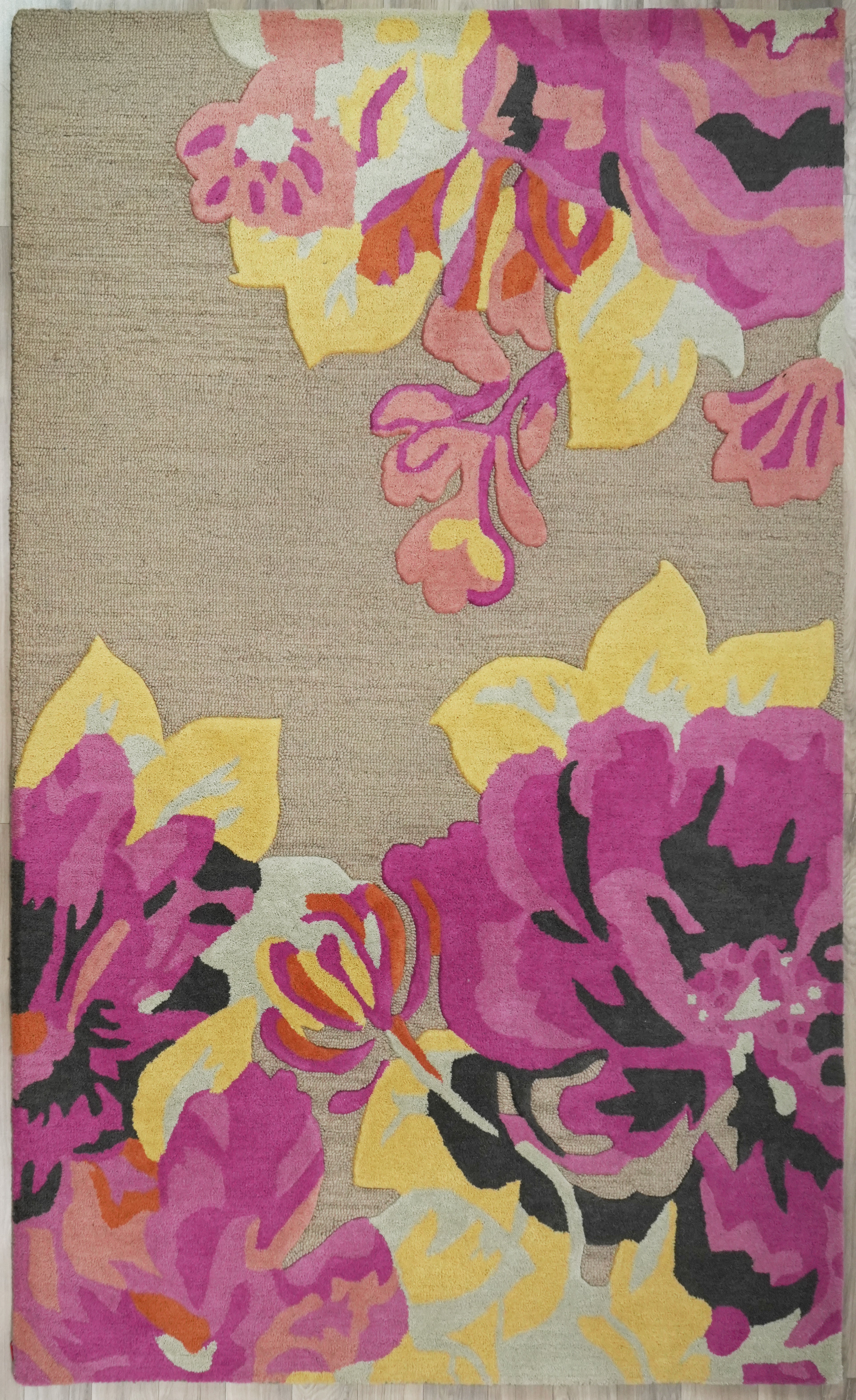 Bloomscape Floral Wool Rug made from 100 % New Zealand wool with hand tufted construction shown in full view featuring oversized floral forms in pink, magenta, yellow, and coral on a neutral base
