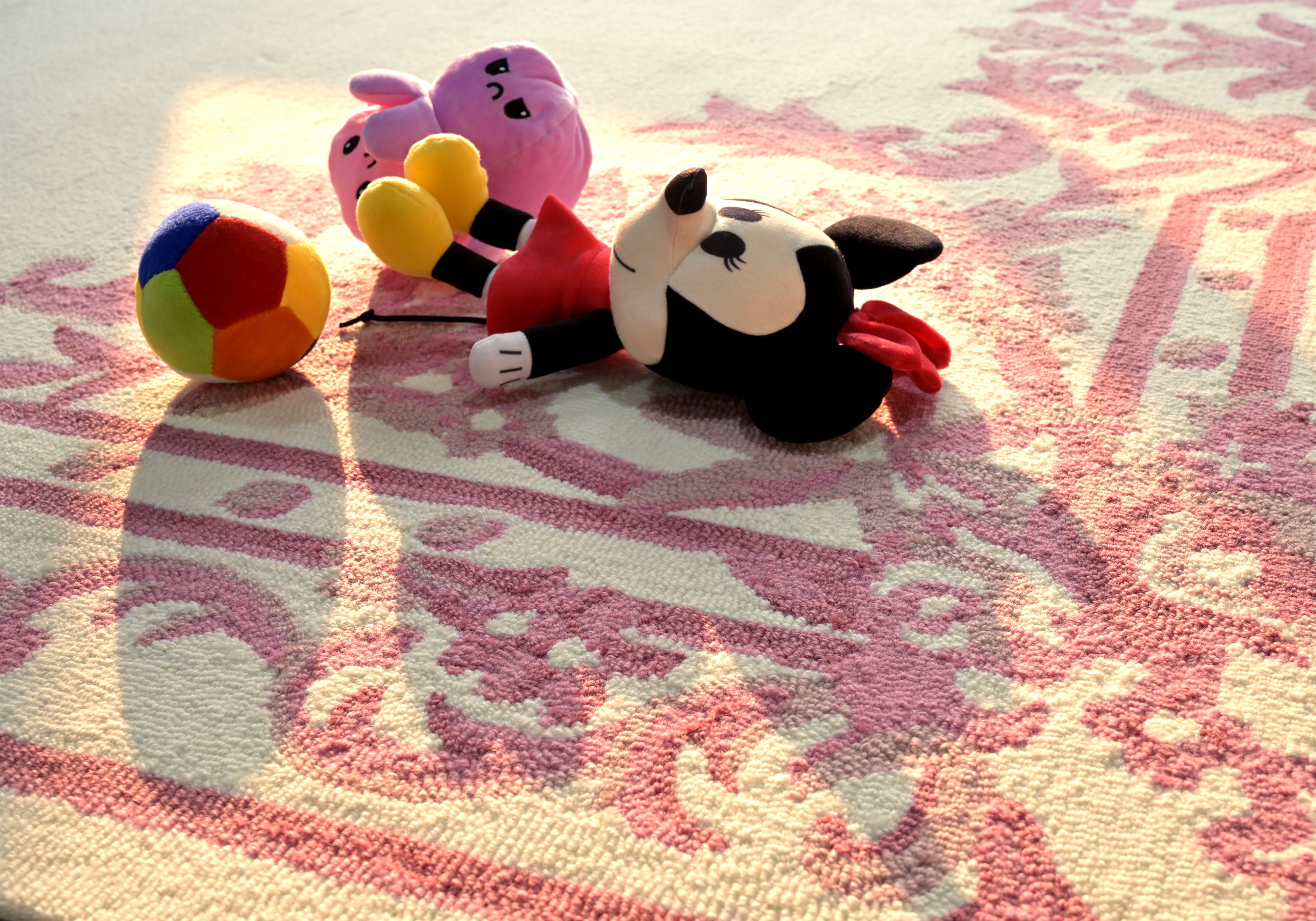Blush ivory hand tufted rug styled with toys showing soft and practical everyday use
