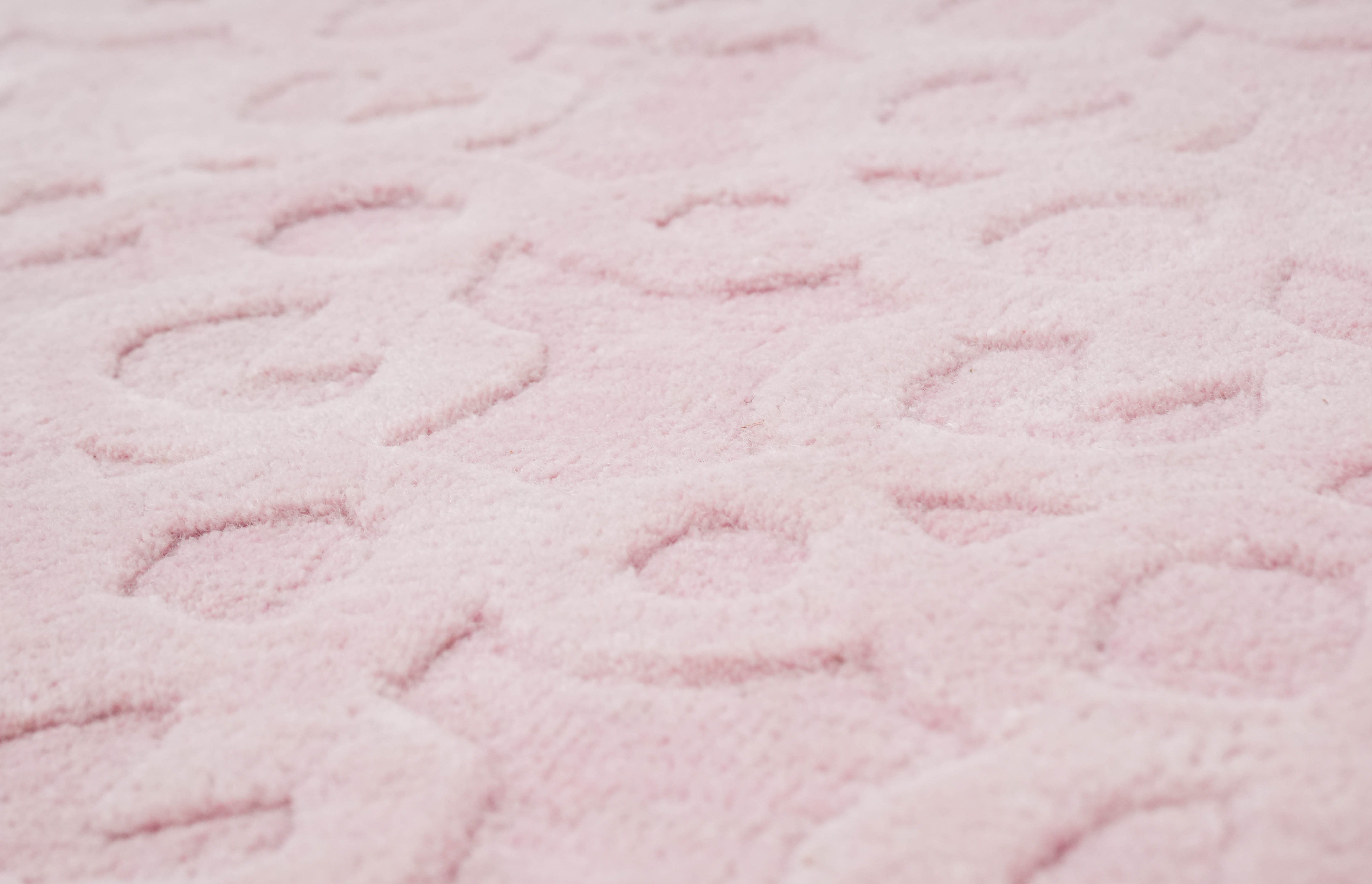 Detailed view of blush pink hand tufted rug showing soft textured surface
