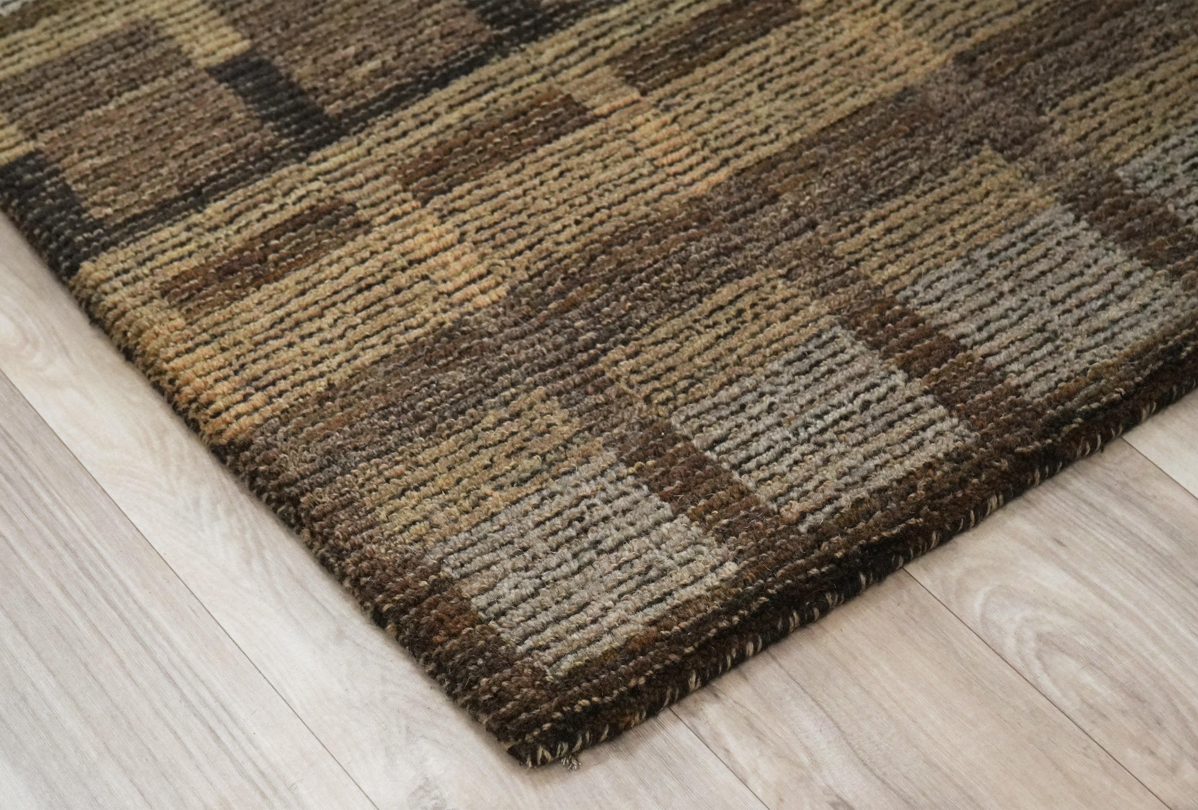 Bronte hand tufted rug with structured earth tone grid design.