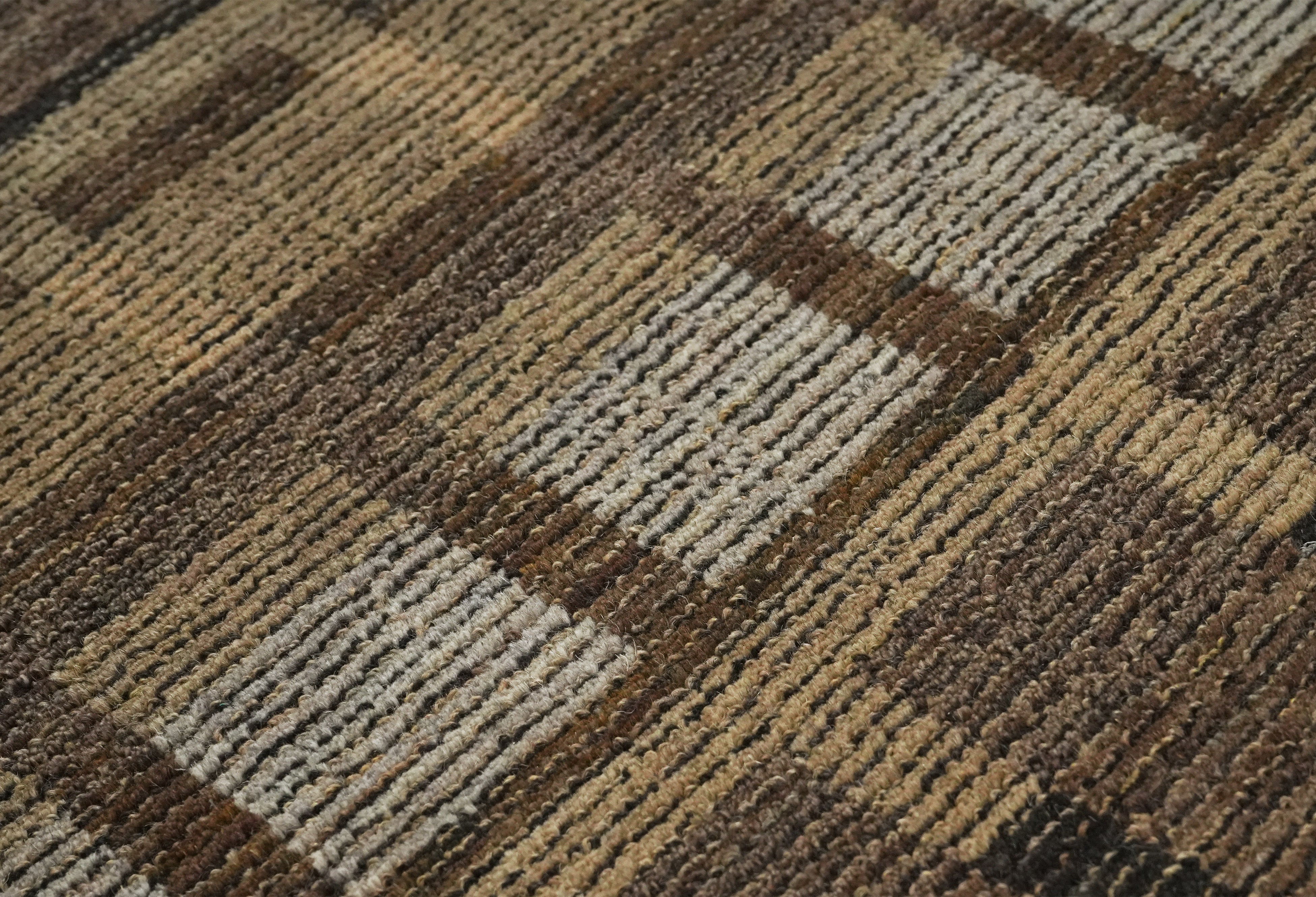 Close up detail of Bronte hand tufted rug showing textured brown and taupe grid.