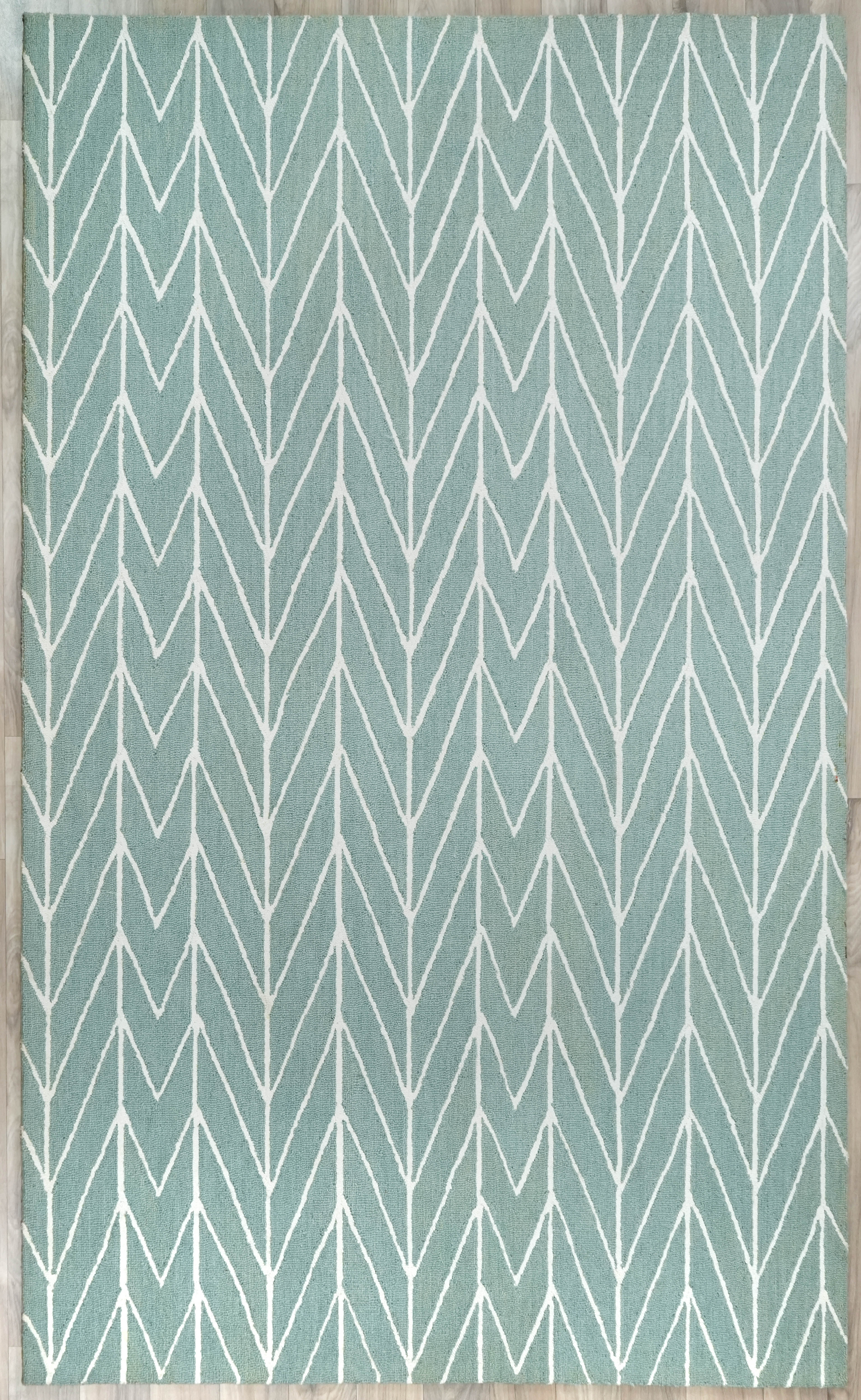 Chevron Drift hand tufted rug in sage green with soft ivory chevron pattern shown in full view