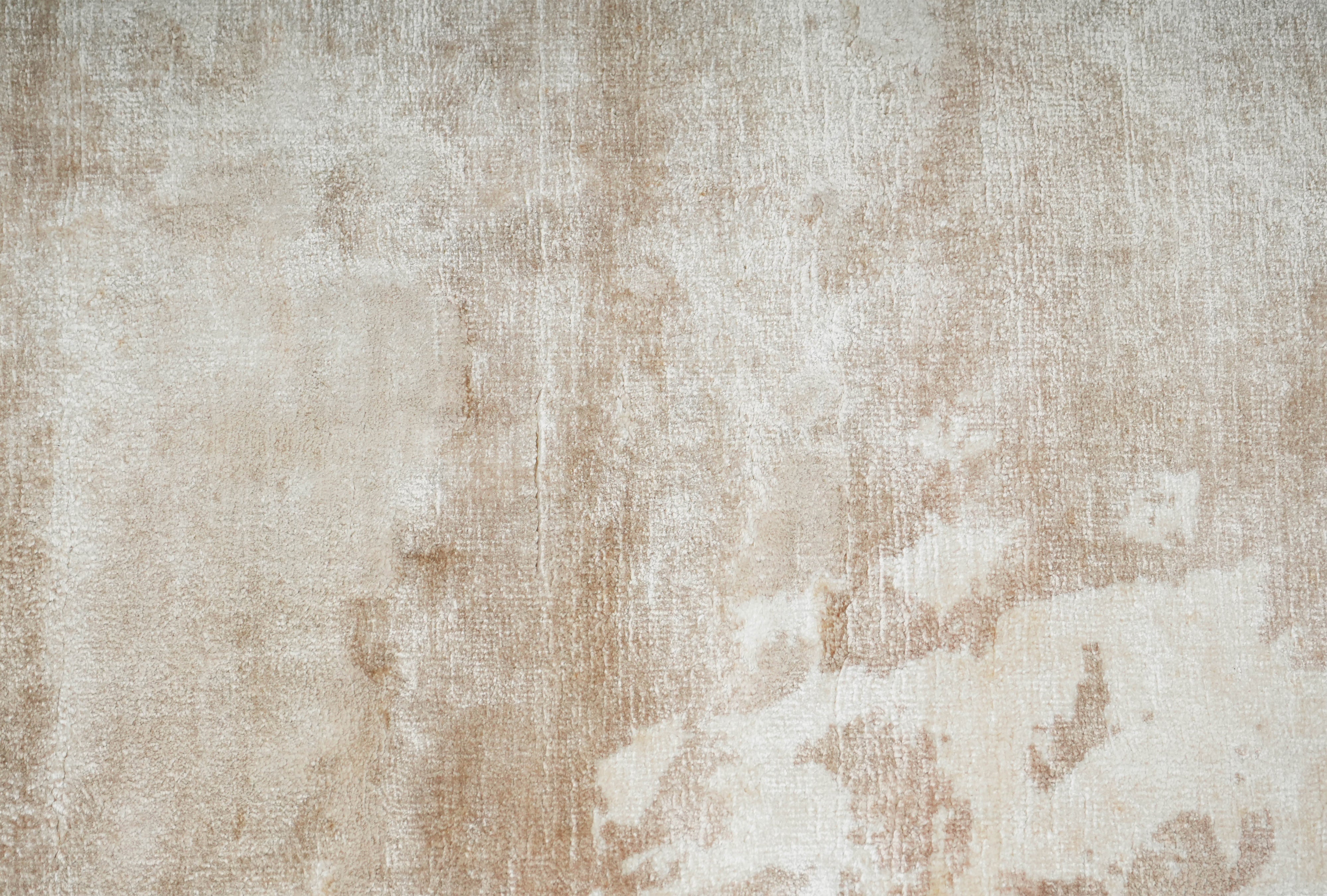 Close up texture of Clouded Earth wool hand tufted rug in layered ivory and earth tones.