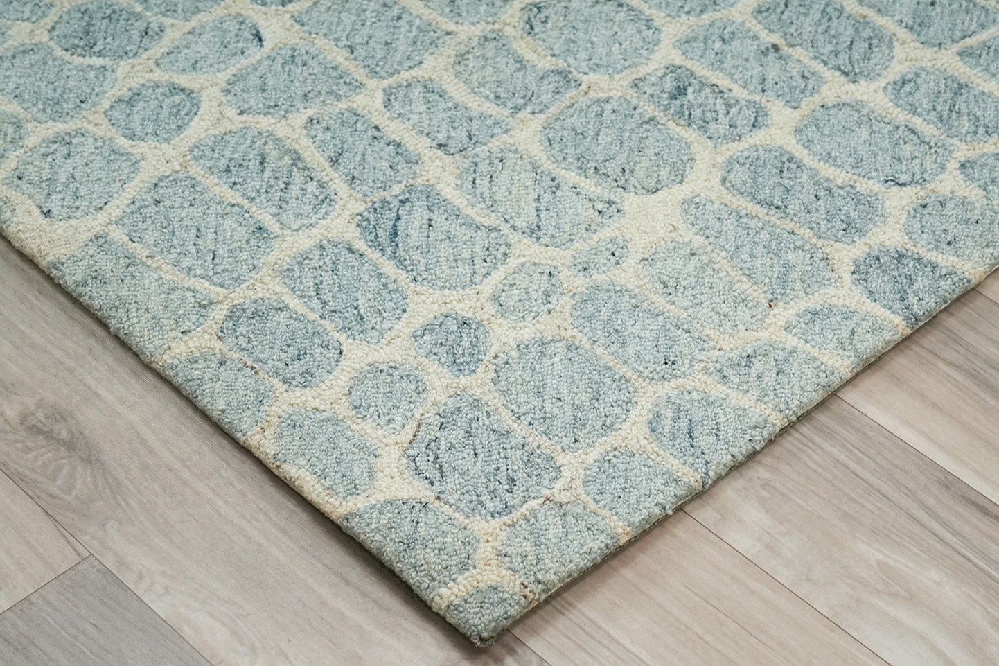 Corner of hand tufted Coastal Stone Pattern Rug showing wool texture and backing finish