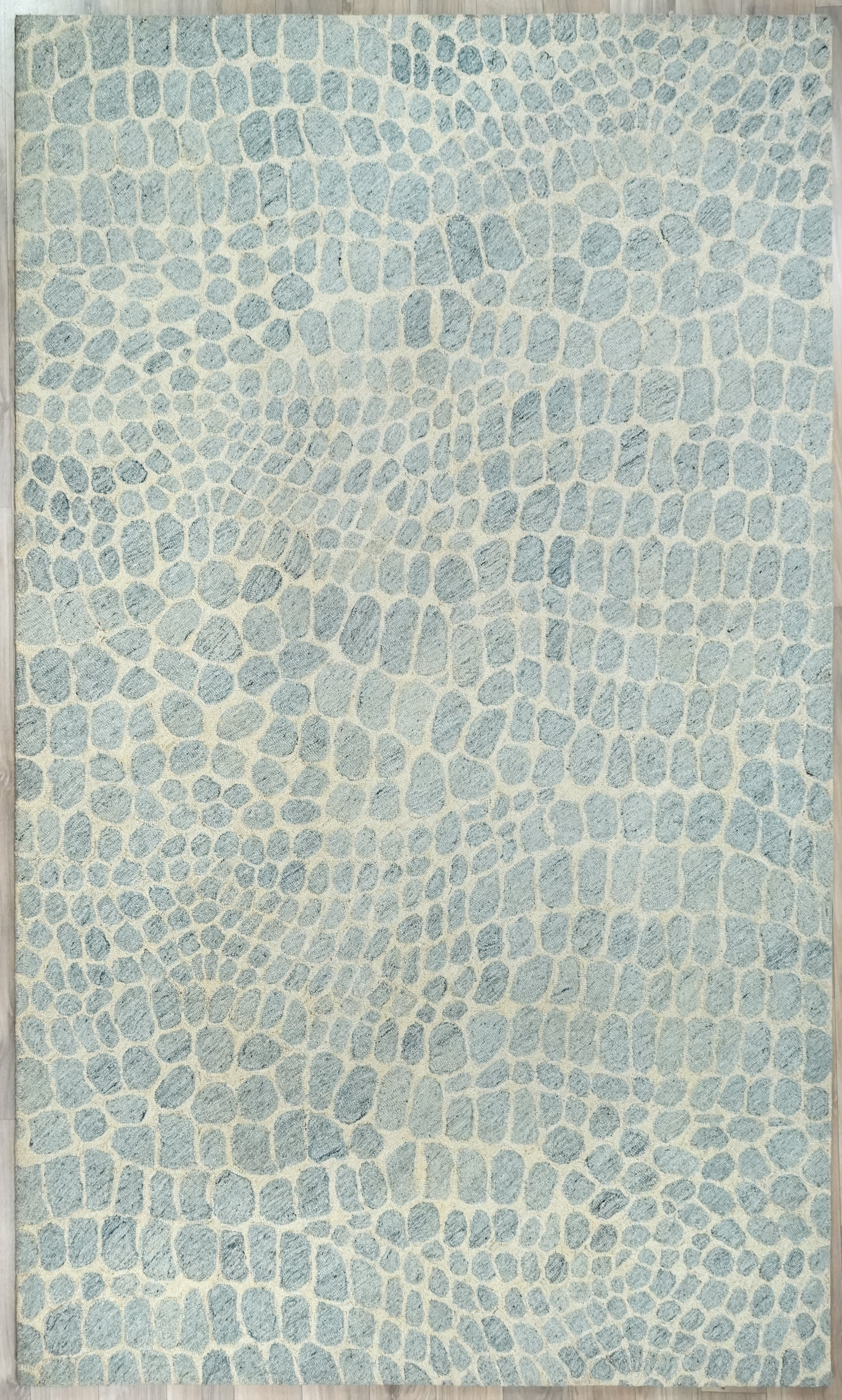 Full view of Coastal Stone Pattern Rug featuring an organic stone pattern in blue tones with hand tufted construction