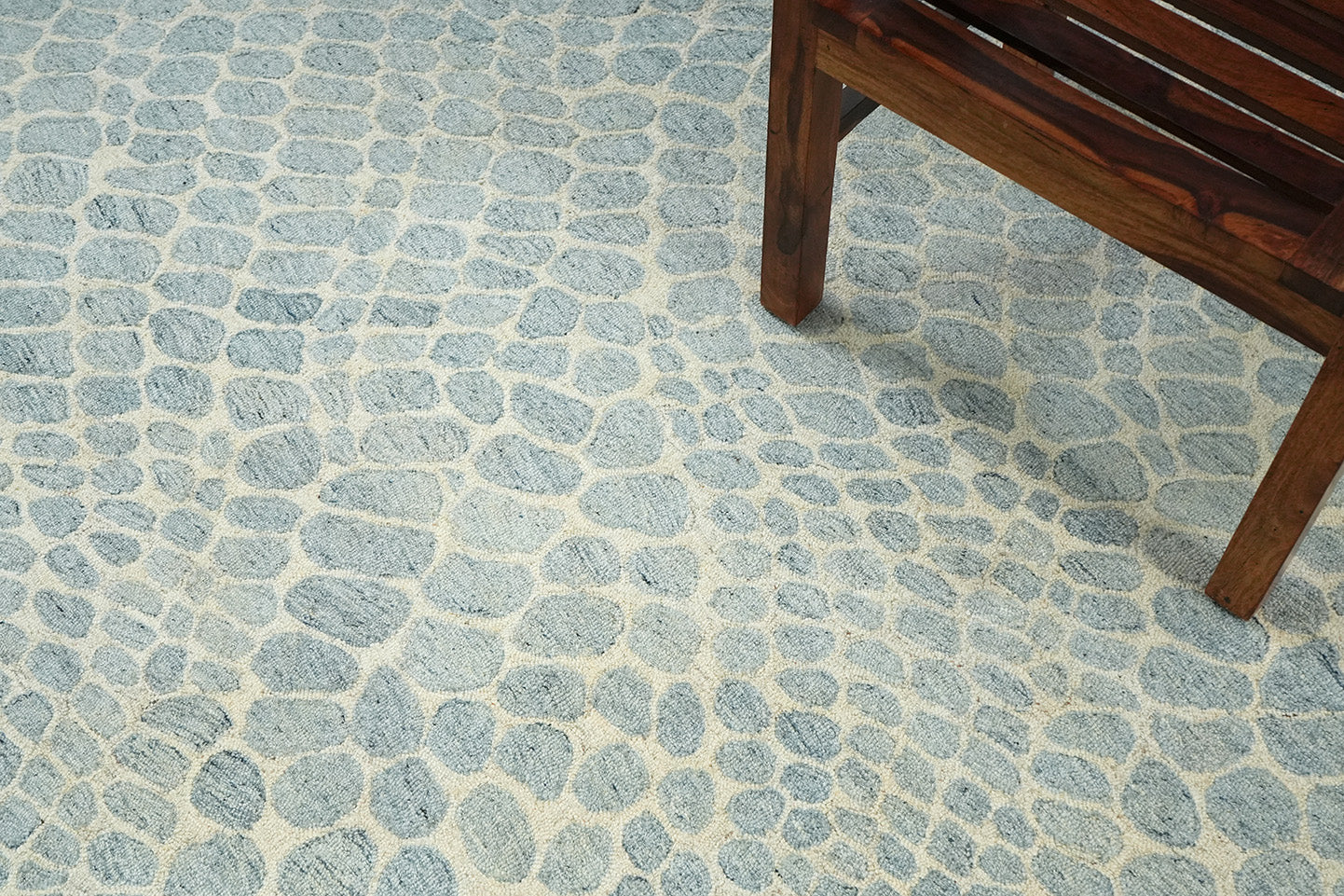 Hand tufted Coastal Stone Pattern Rug placed in a living room showing soft blue stone inspired pattern under furniture