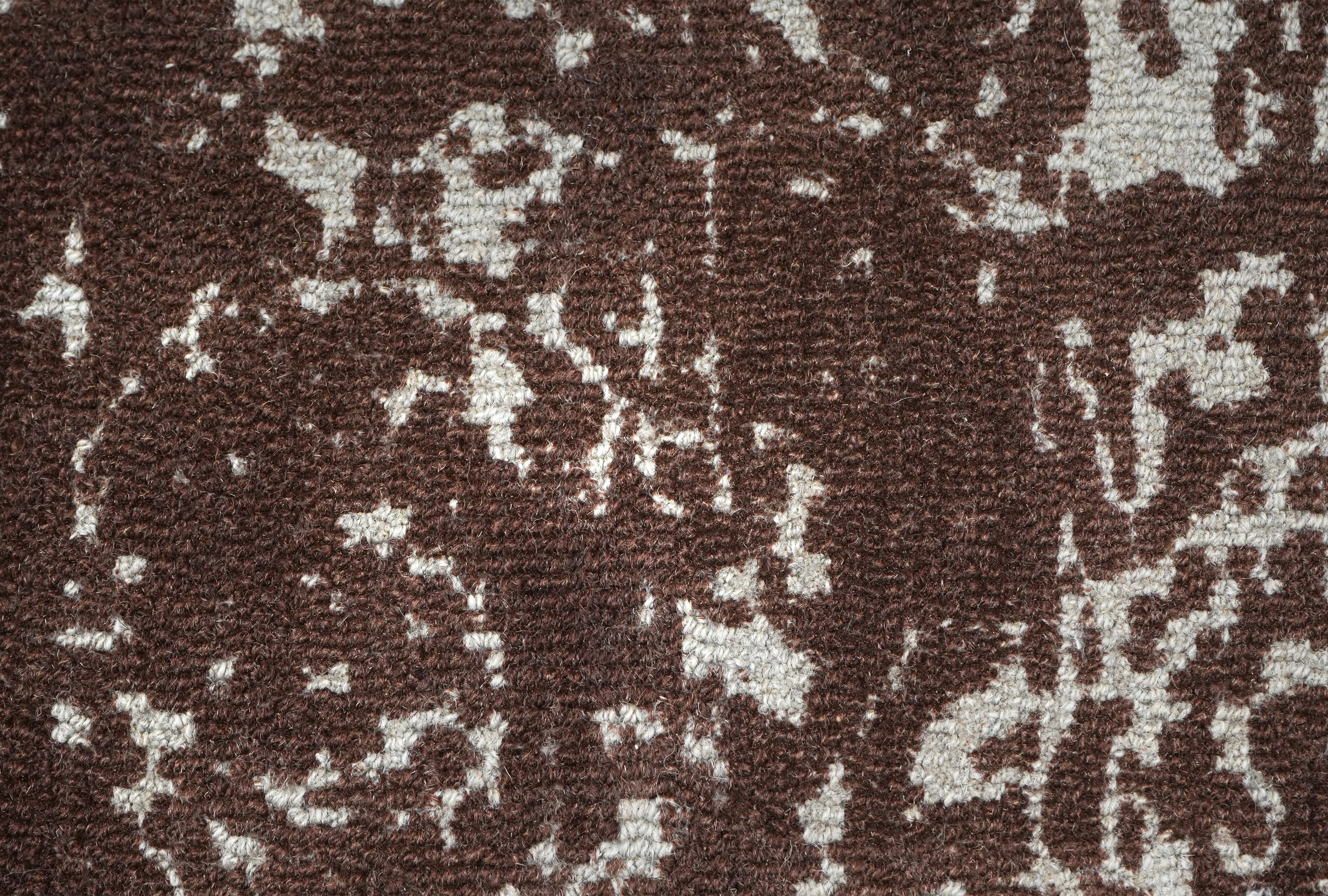 Cocoa Relic wool rug close up of distressed brown medallion pattern on ivory base