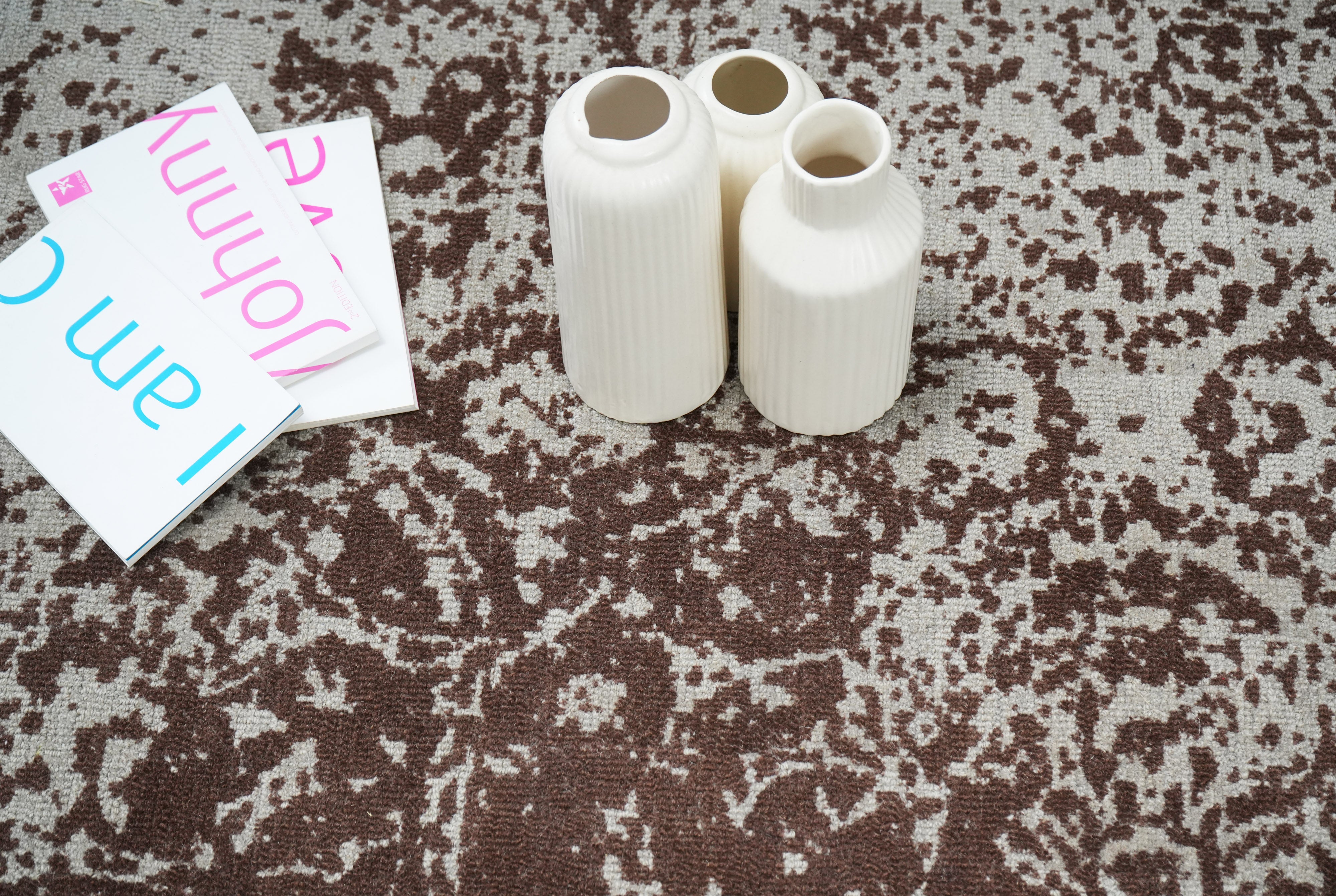 Cocoa Relic wool rug close up showing ivory base with deep brown distressed pattern and decorative styling