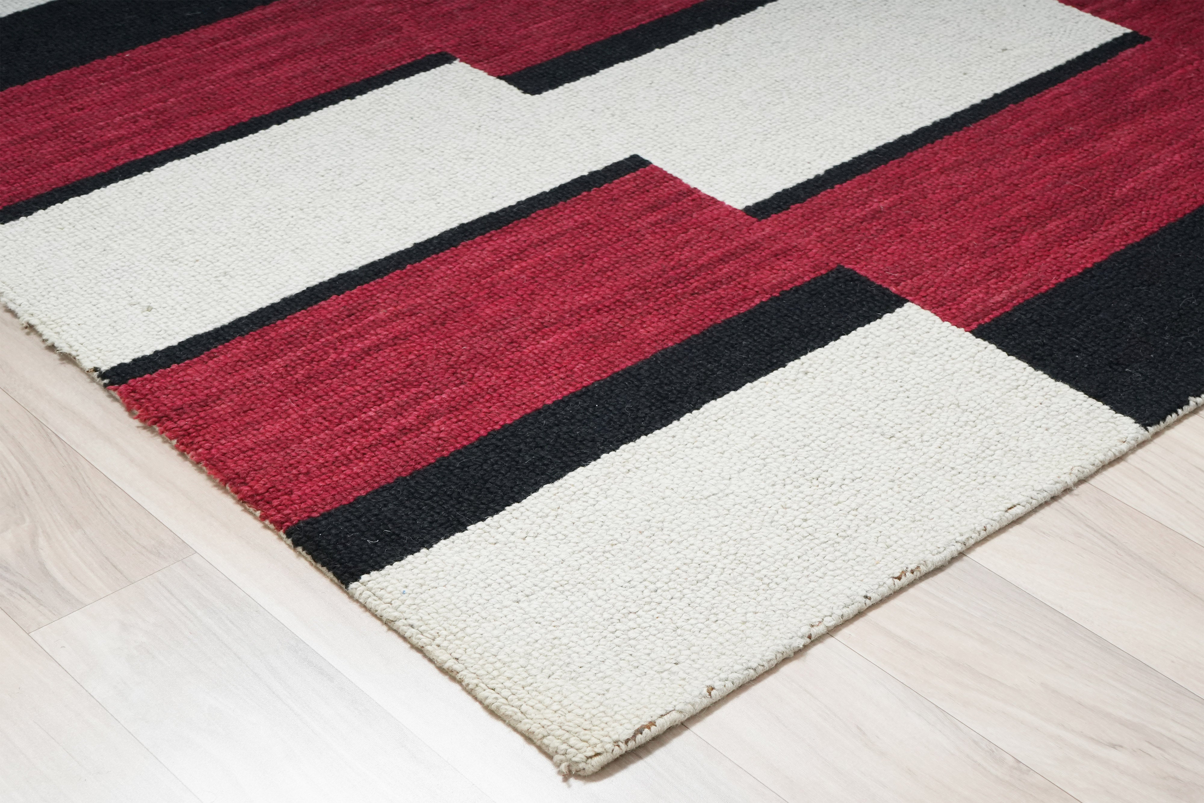 Corvane hand tufted rug showing bold red and ivory block pattern.