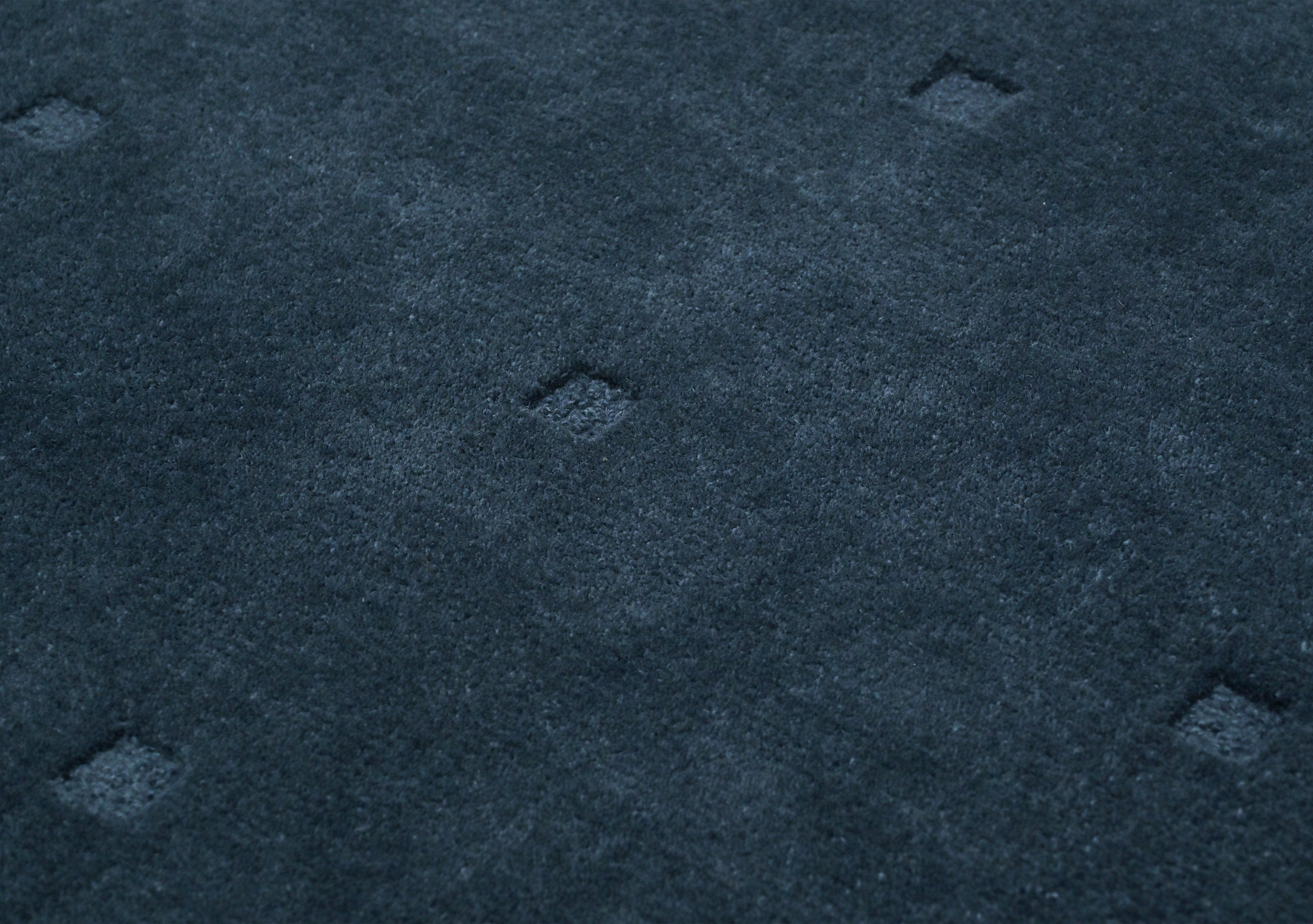dark blue grid rug close up showing wool texture and subtle grid pattern