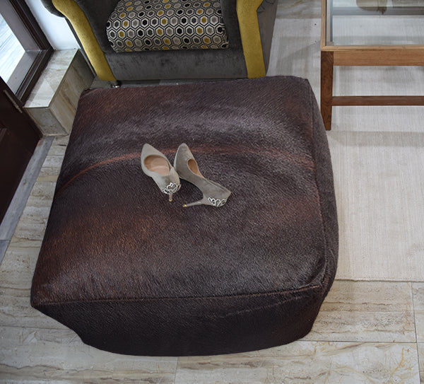 dark brown handmade leather pouf ottoman in a room setting
