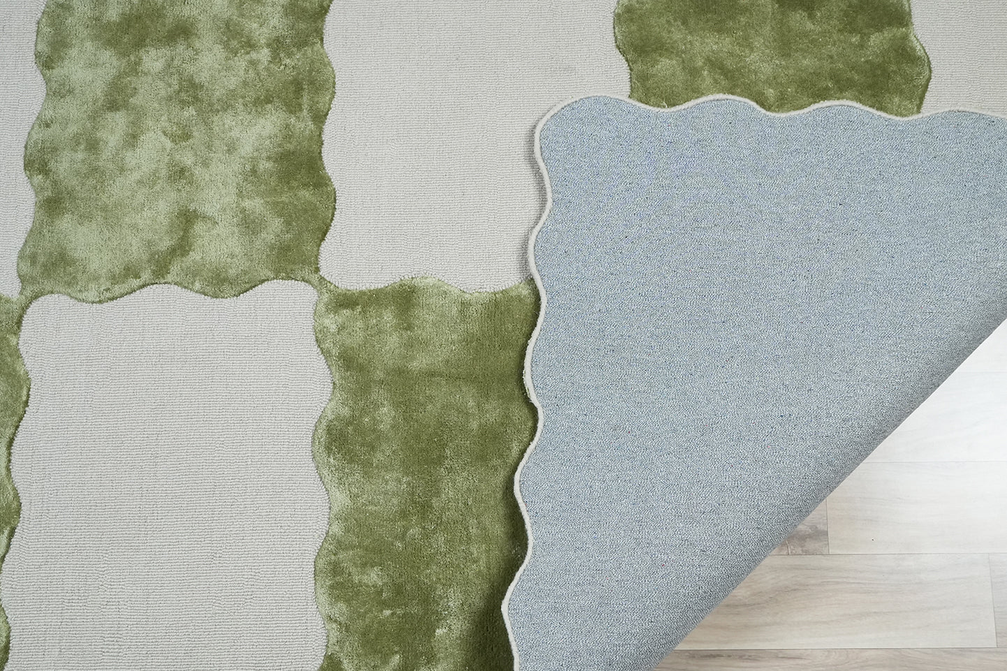 Decordec sage scallop check hand tufted wool area rug folded corner showing cotton backing and thickness.