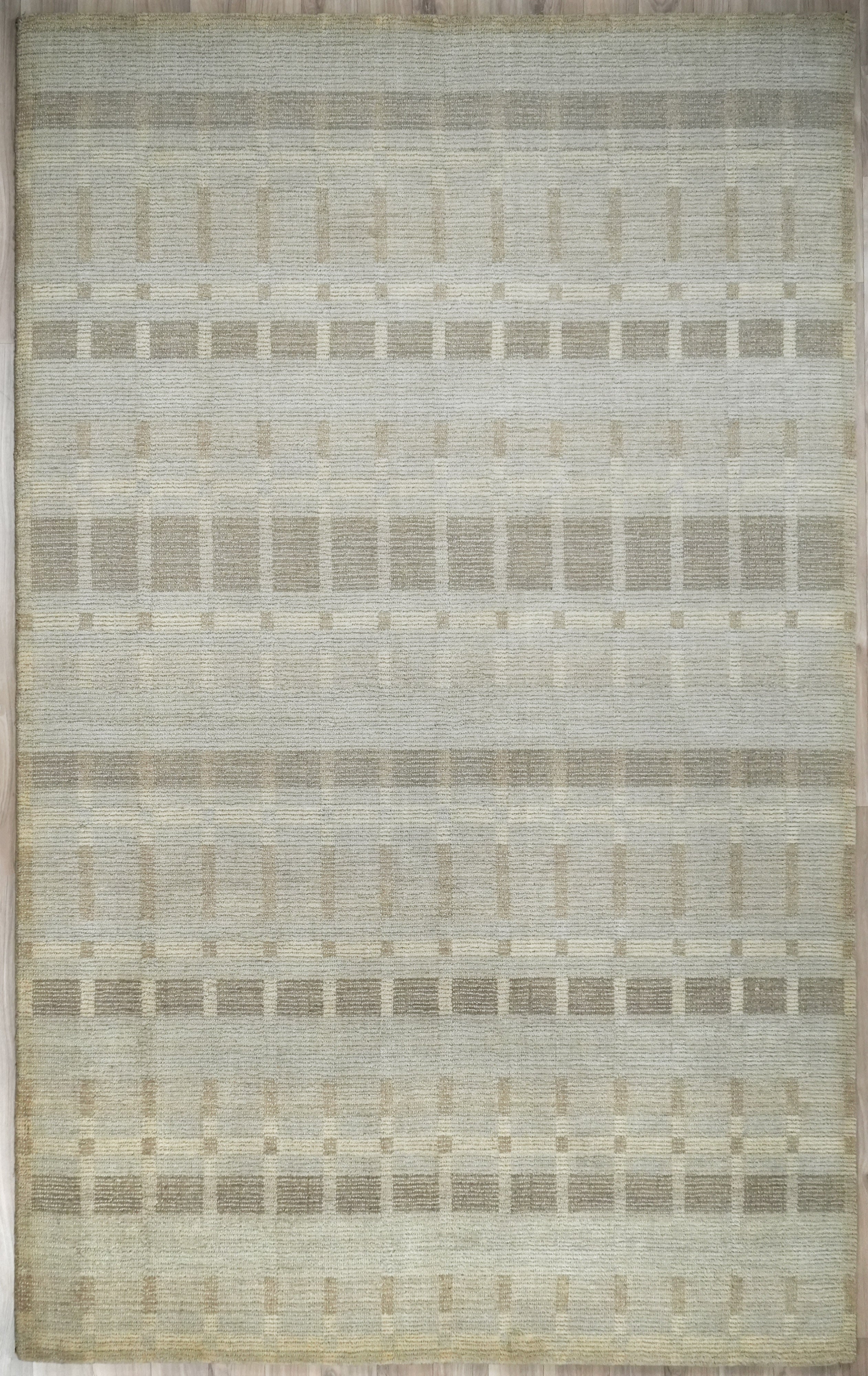 Full view of Elaron hand tufted rug in soft beige neutral pattern.