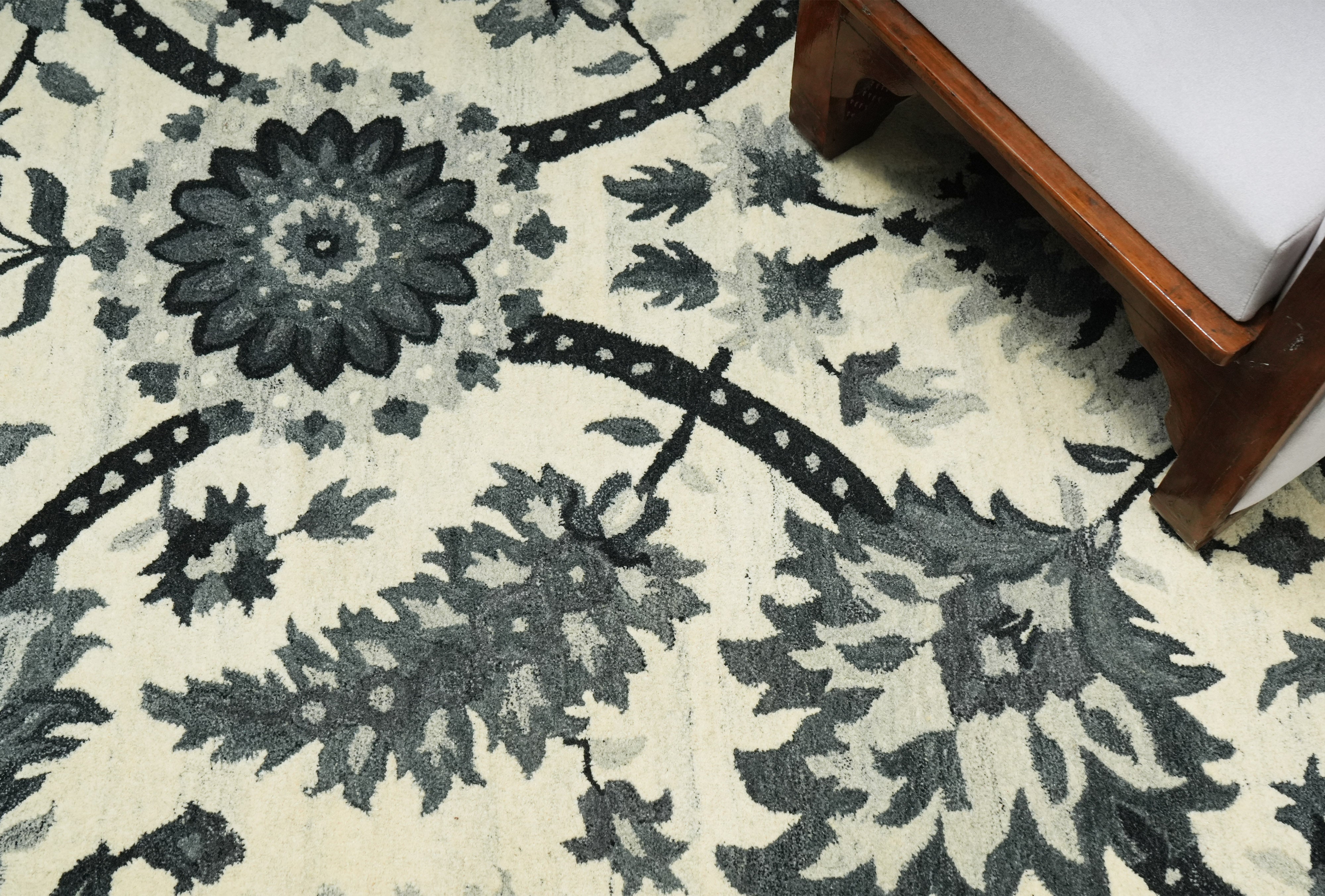 Detailed botanical pattern of Elmsworth wool rug in charcoal grey over ivory base.