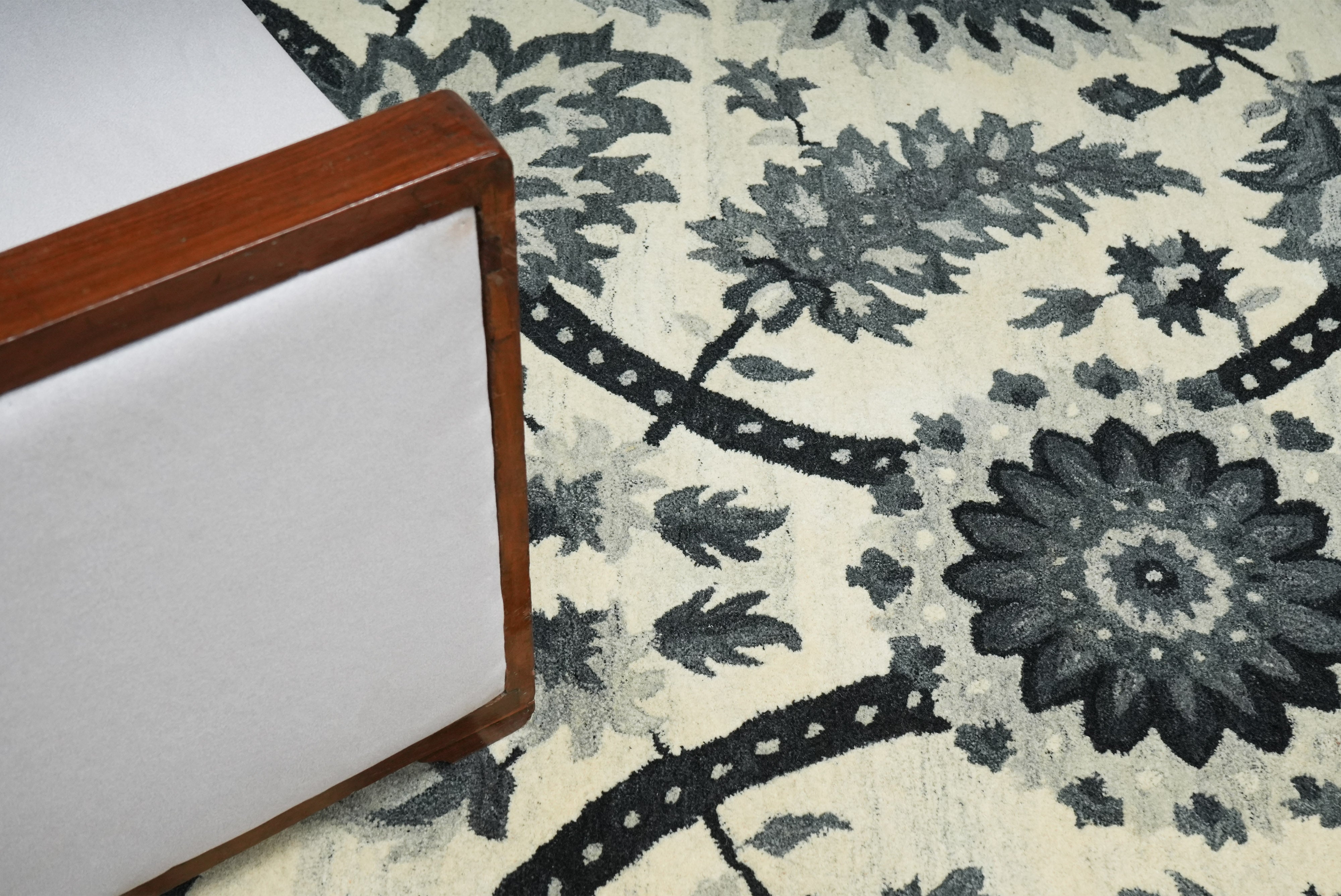 Elmsworth wool rug styled in interior setting with ivory and charcoal heritage floral design.