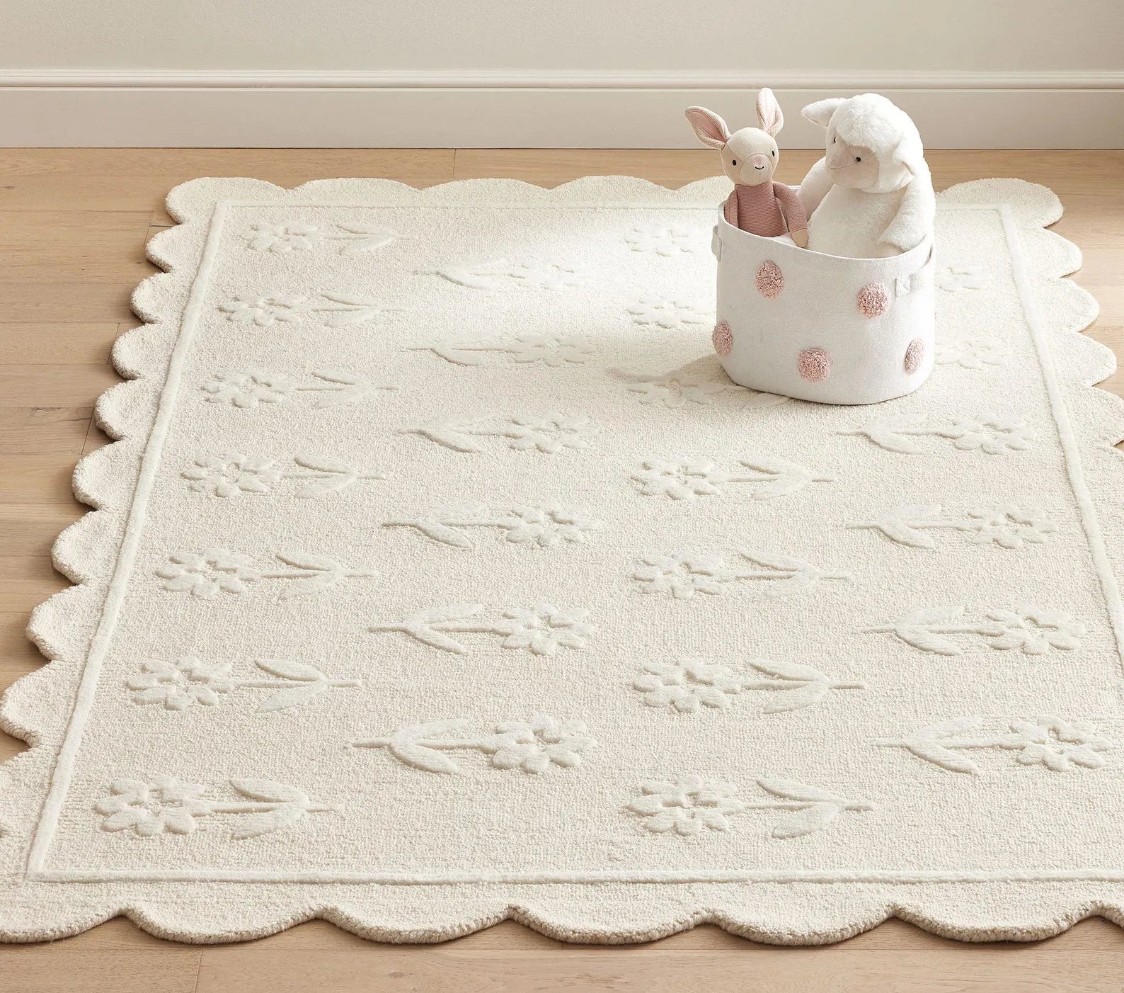 Flourish Rug styled in a warm neutral room with scalloped edges and soft floral texture