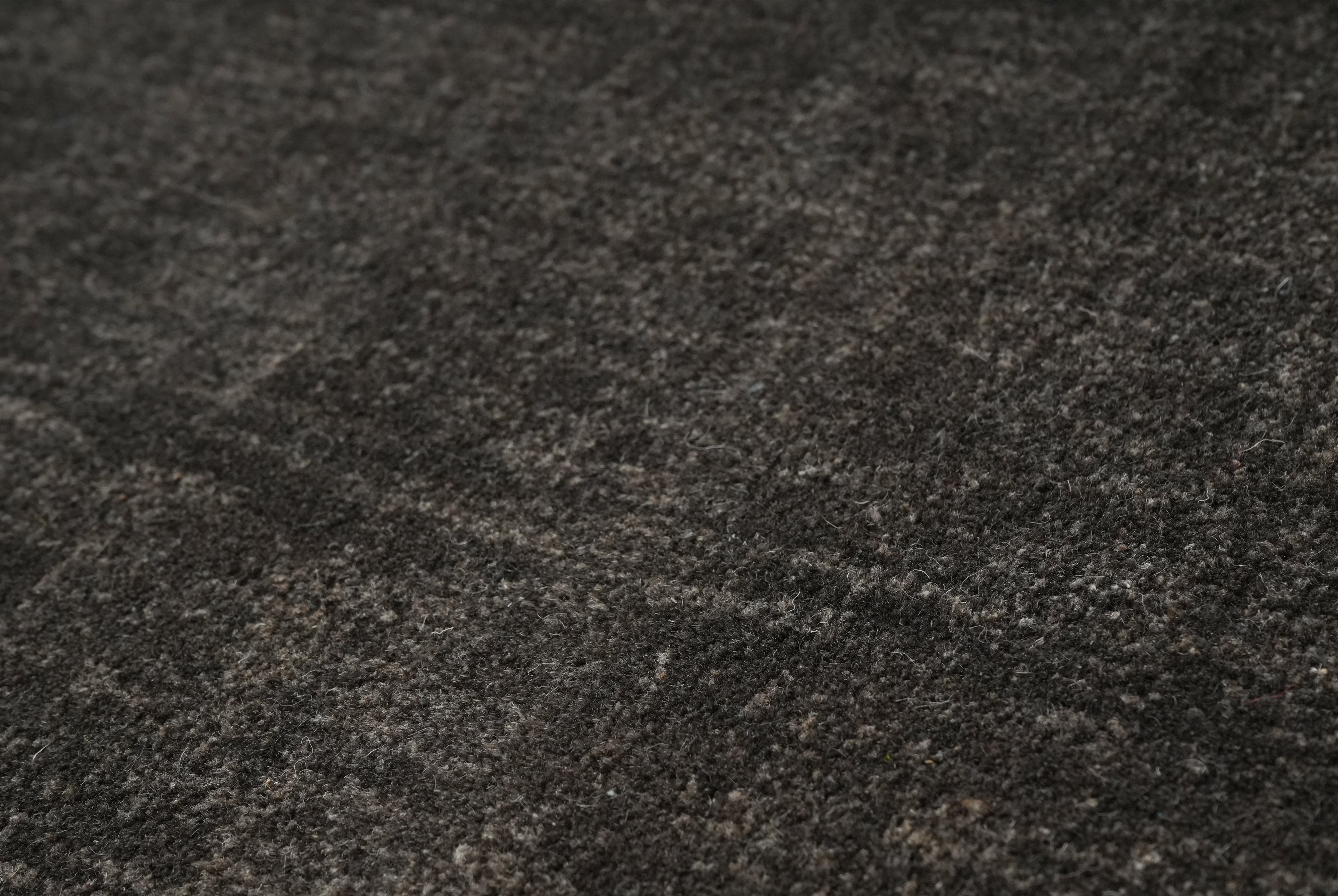 Close up texture of Graphite Shadow charcoal wool hand tufted rug surface.