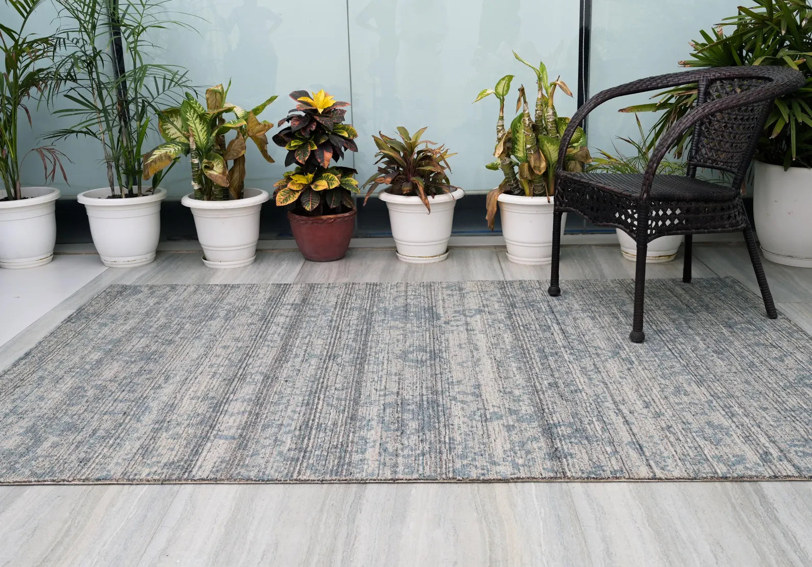 hand tufted Azure Fade Rug styled in a patio setting with plants and natural light