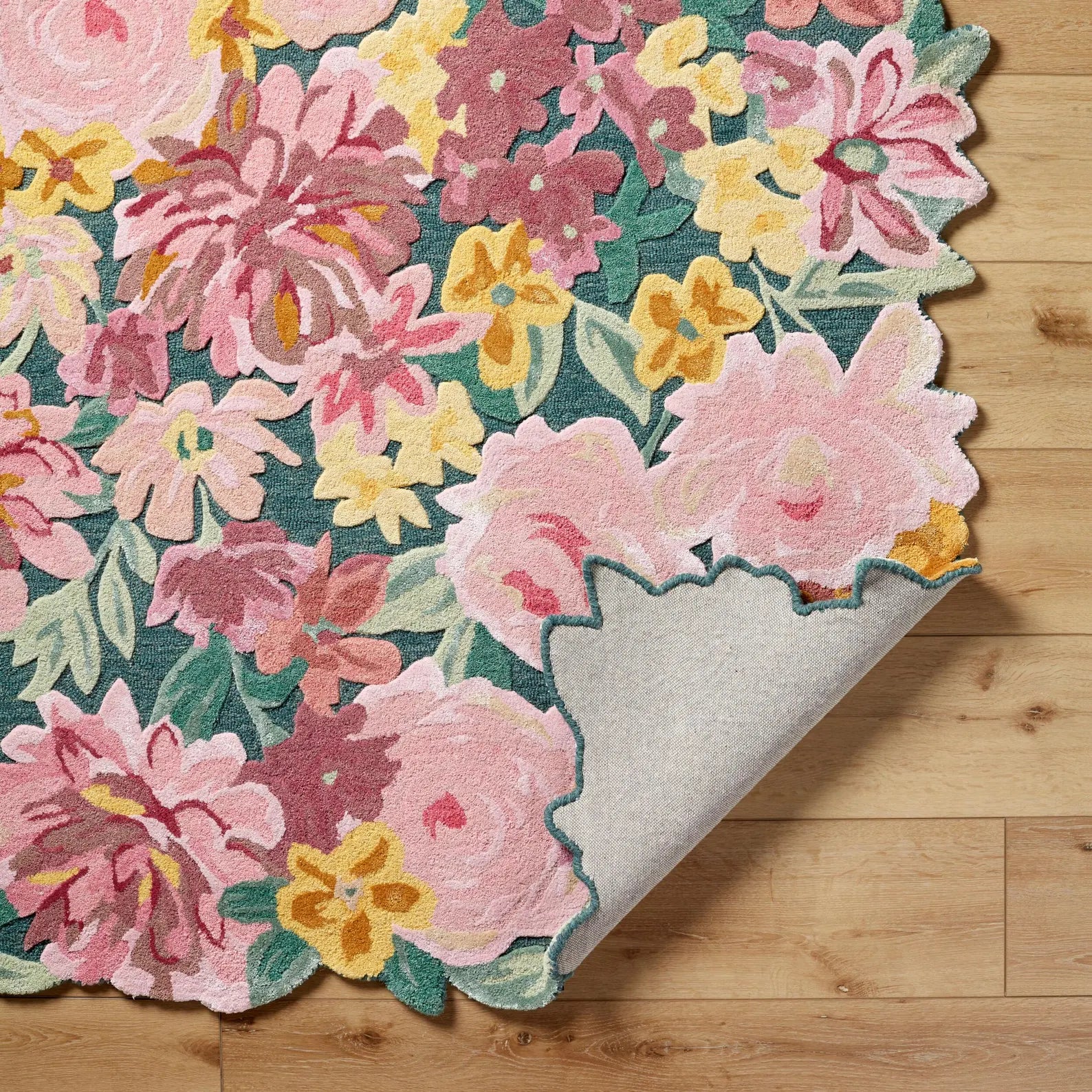 Hand tufted Floral Fantasy Wool Rug corner fold showing raised floral edges and plush wool texture with pink, yellow, and green botanical motifs.