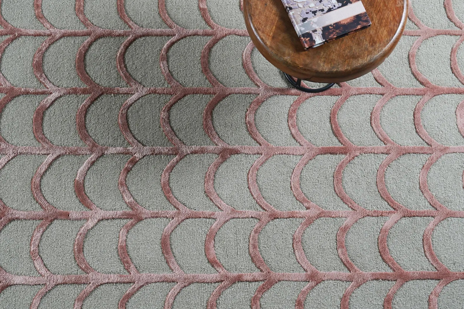 Hand tufted Geometric Scallop hand tufted rug in a styled top-angle view with a wooden stool, showing its textured scallop pattern.