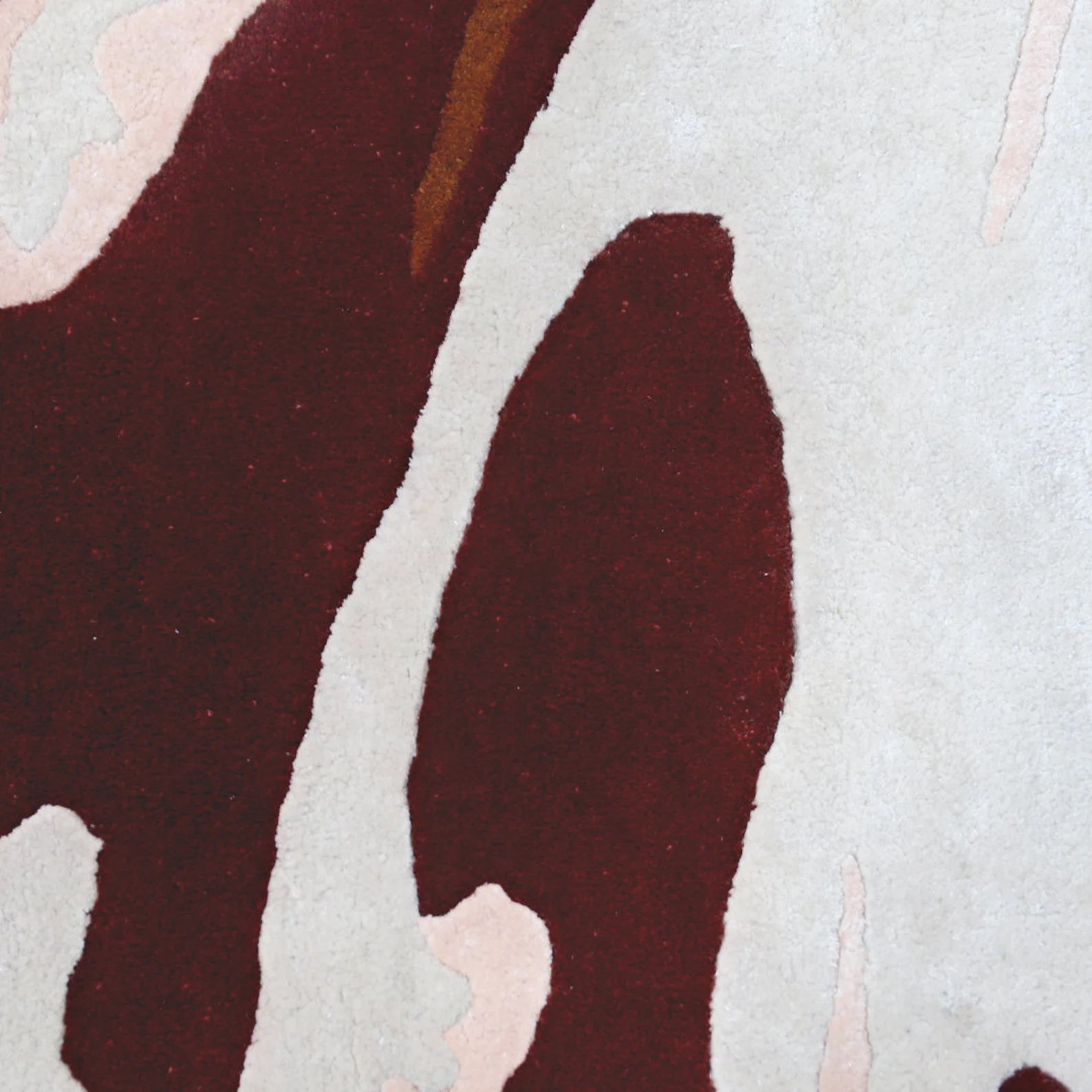 Close-up of the hand tufted Hazel Rug showing its wool texture and rich brown abstract design on a cream base.