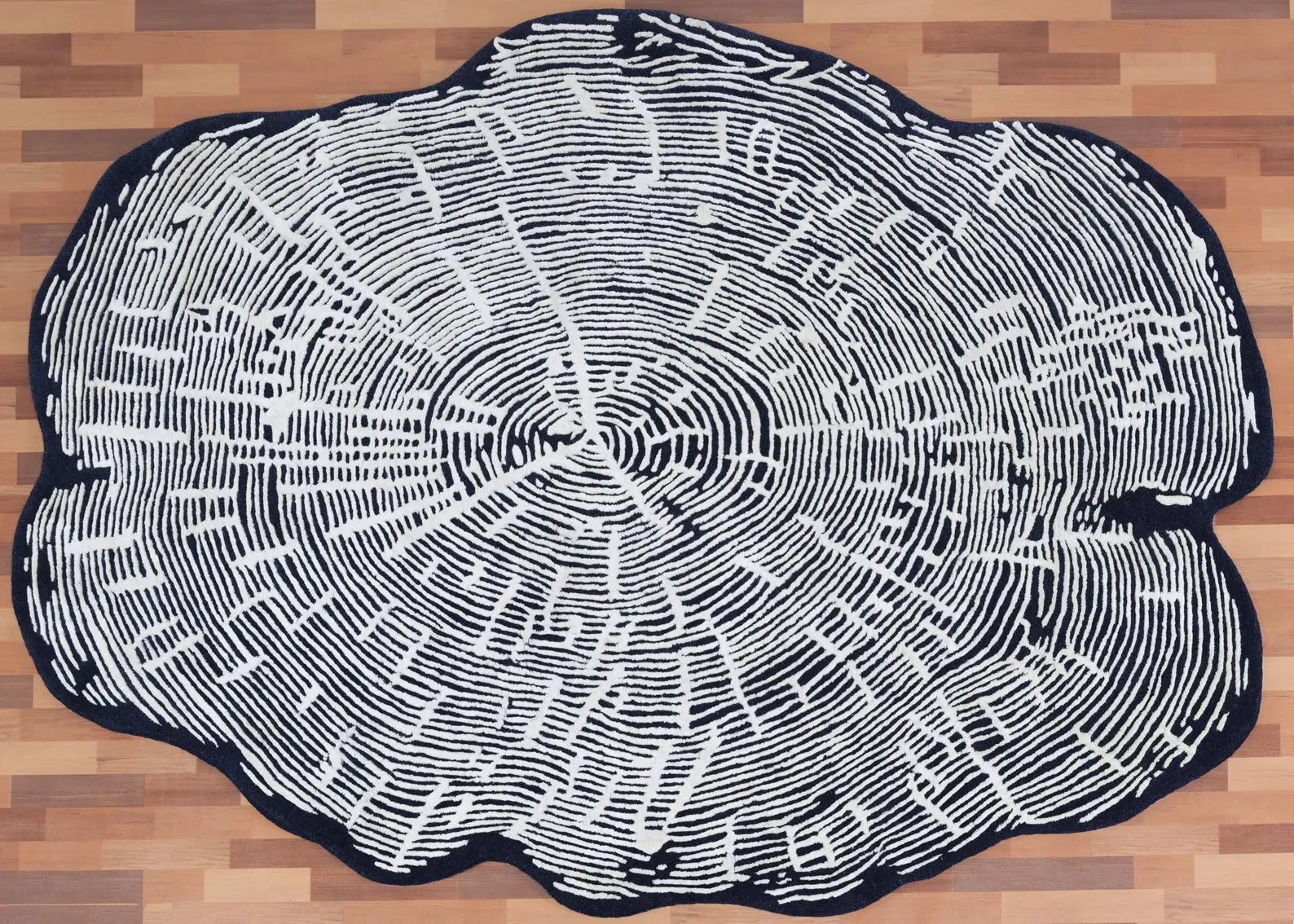 Hand tufted Sequoia Rug captured from a top angle showing its full organic silhouette and intricate white vein pattern on a deep charcoal base.