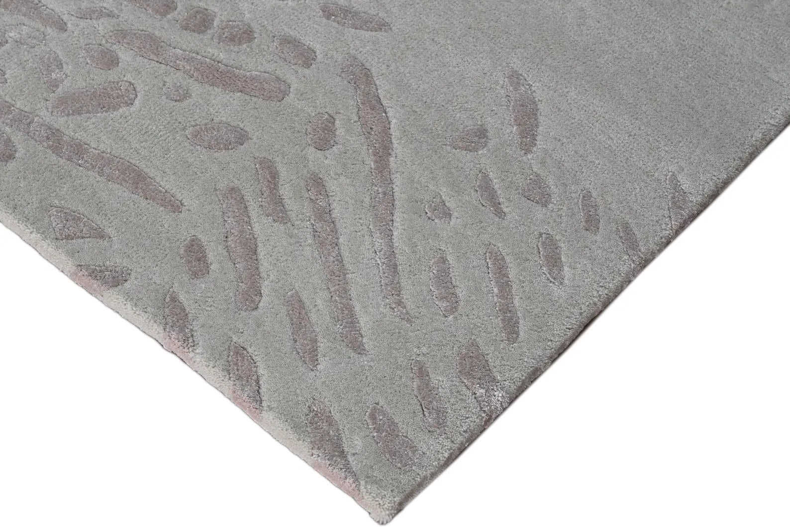 Corner view of the Dune Relic hand tufted rug showing its soft curved edge and dune-inspired textured pattern.