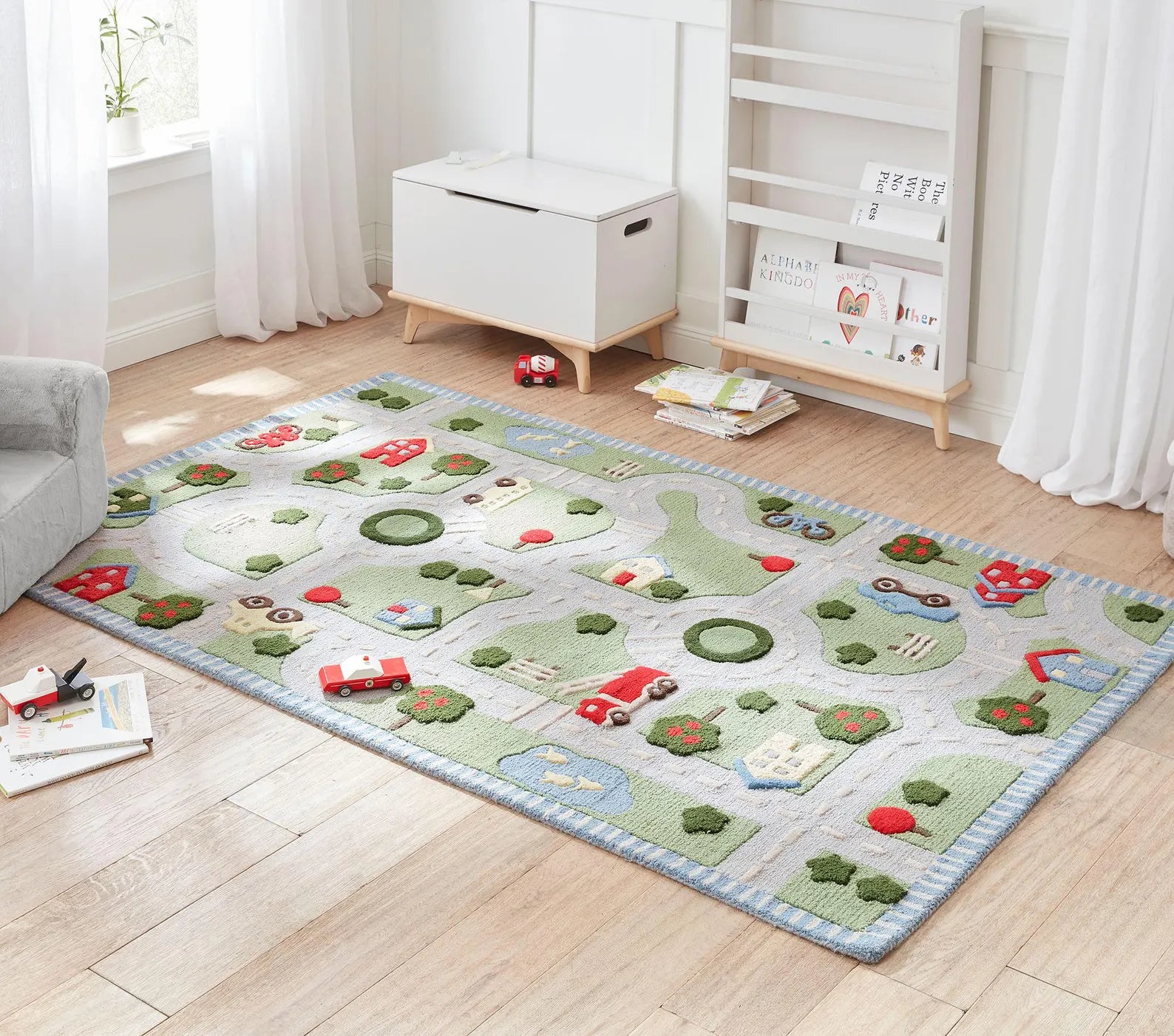 Hand tufted Road Map Rug placed in a bright kids room showing playful roads houses cars and trees on a soft textured surface.