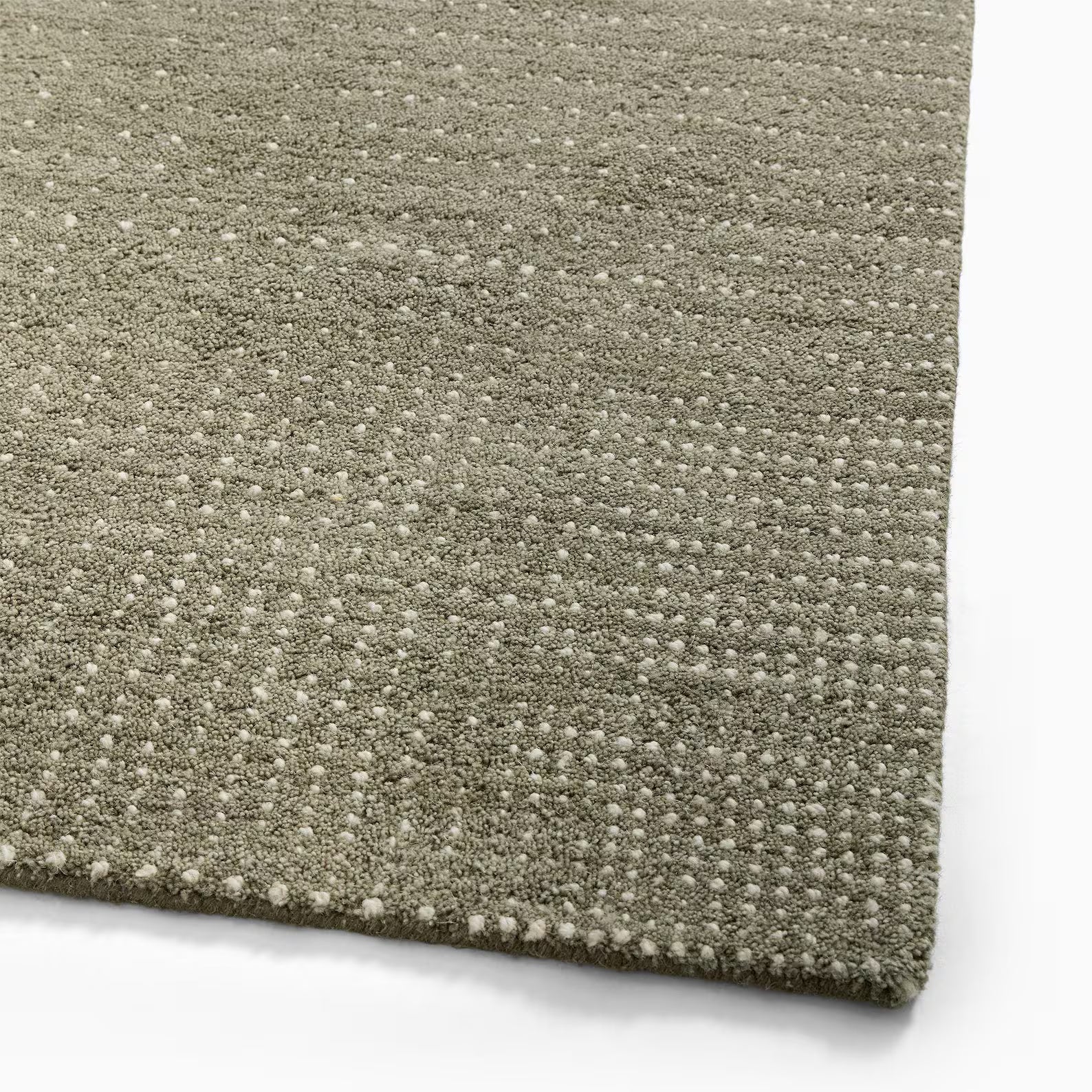 Close-up corner of green dot texture wool rug with hand-tufted edge and durable backing – Decordec