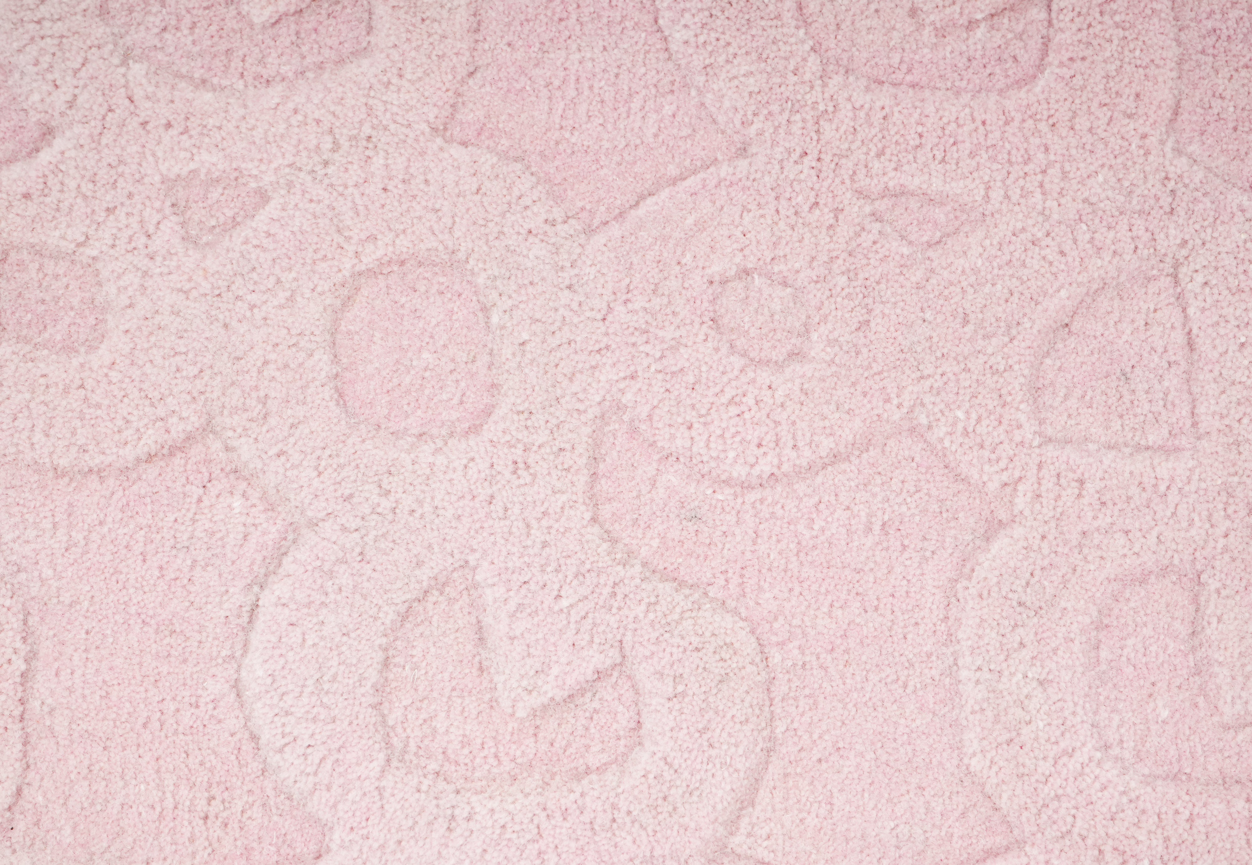 Close up of light pink hand tufted rug highlighting subtle embossed pattern