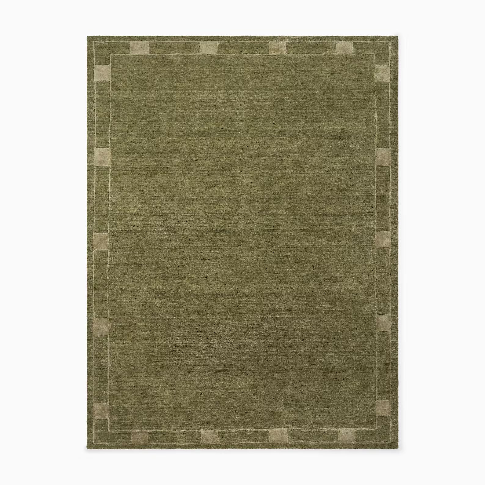 Top view of an ochre hand tufted rug with a soft bordered pattern, styled in an earthy mid-century space.