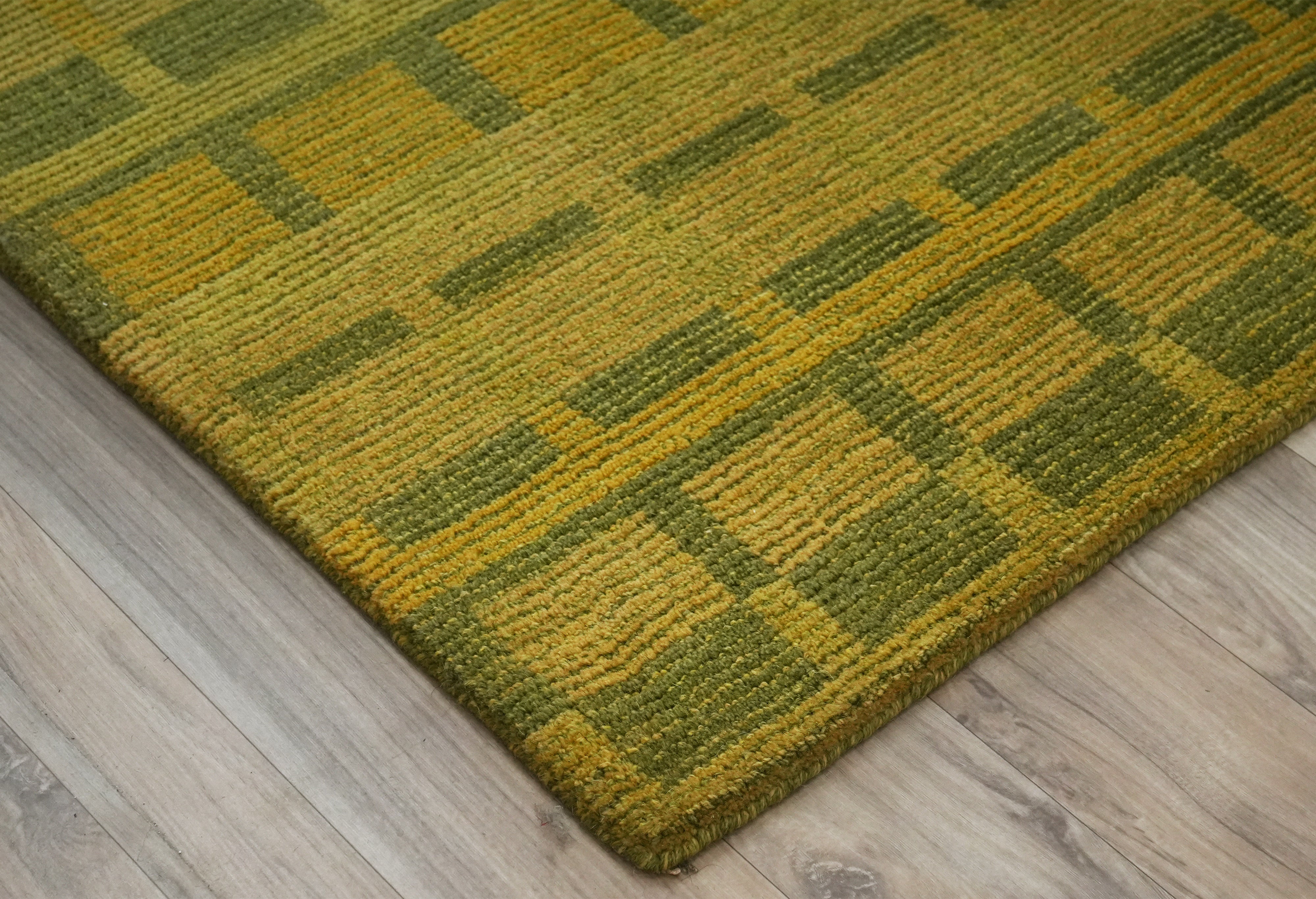 Olivara hand tufted rug showing structured olive green lattice design.