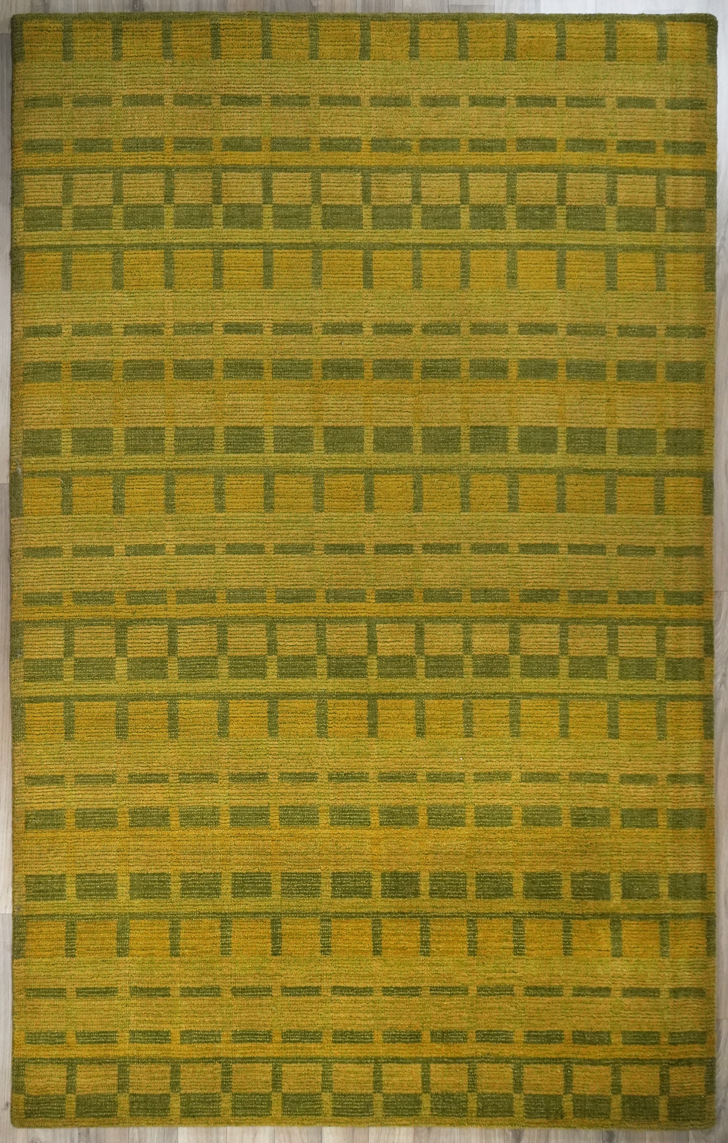 Full view of Olivara hand tufted rug in olive green and mustard grid pattern
