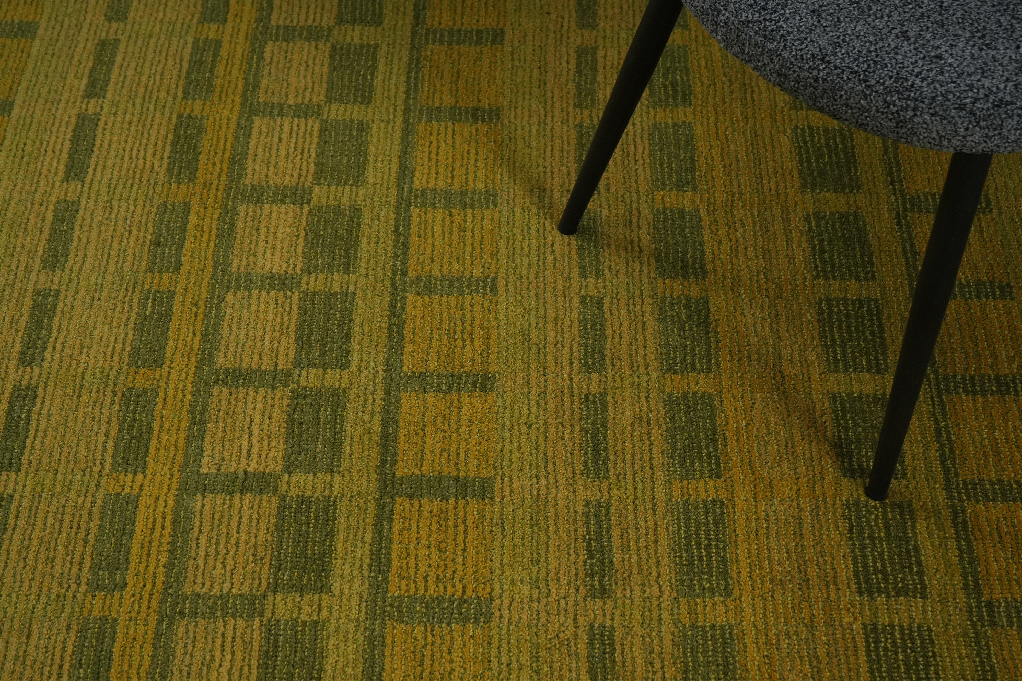 Olivara hand tufted rug styled in modern interior with olive and golden tones.