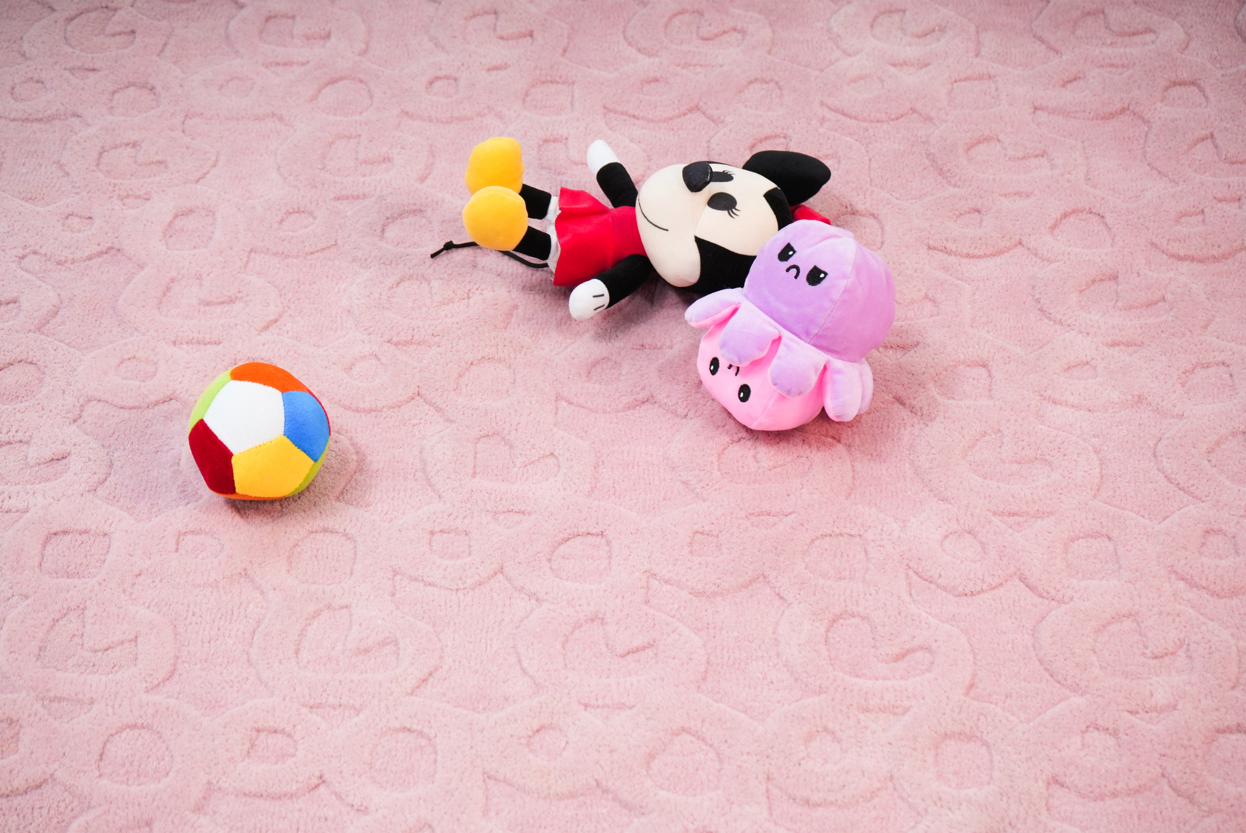 Pink hand tufted rug styled with toys showing soft and playful kids setup