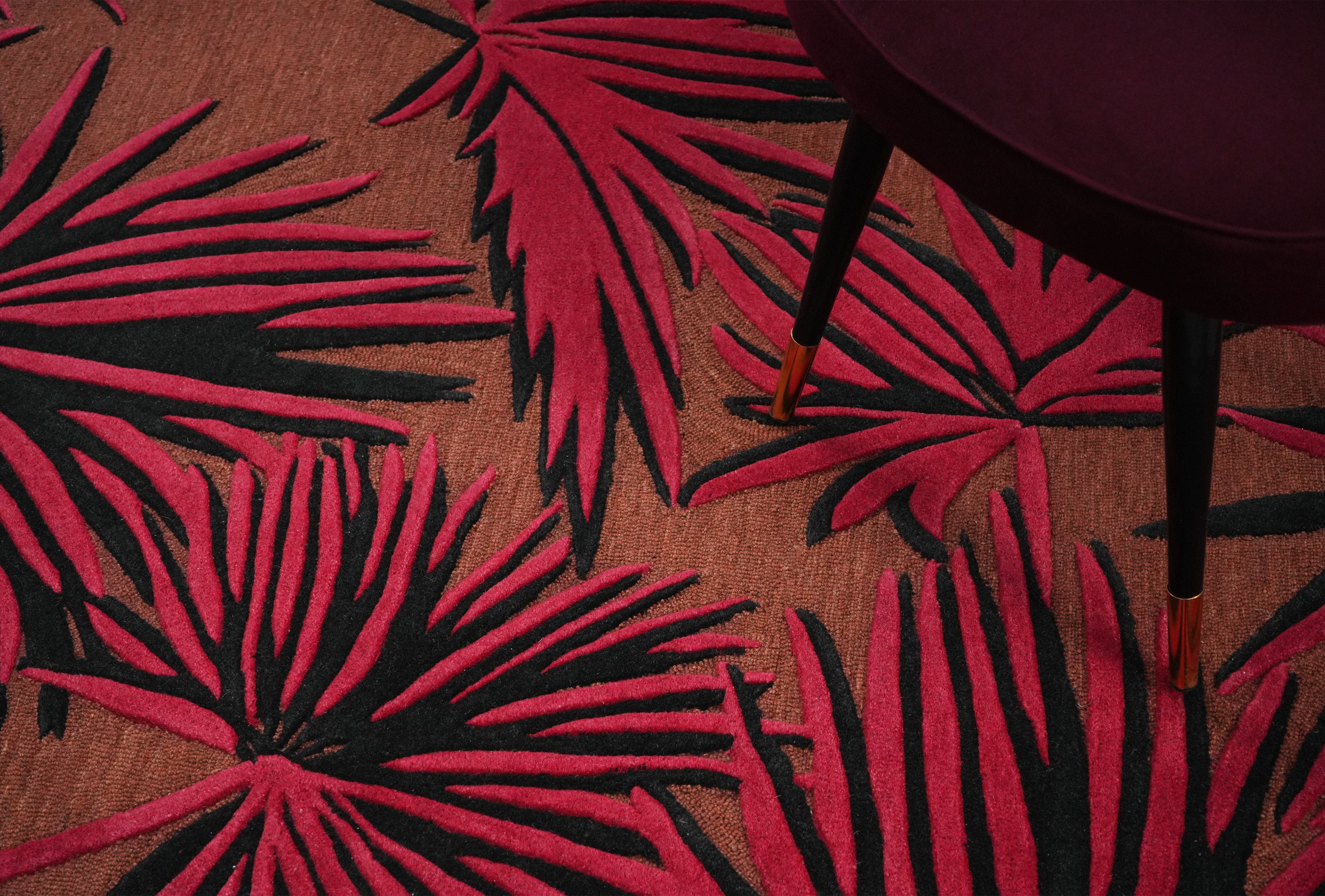 Close up of red and black palm silhouette on Red Palm Noir area rug