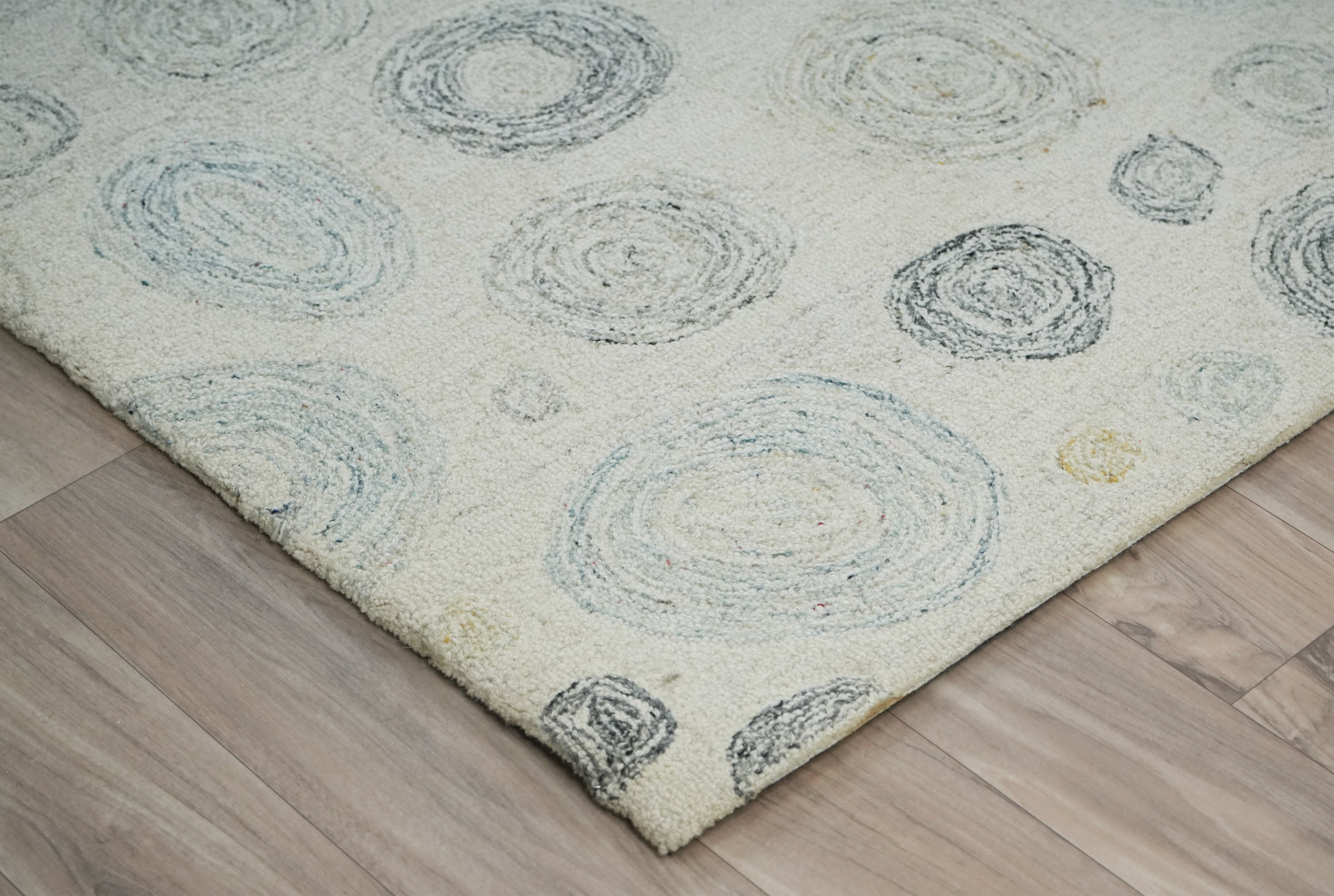 Ripplea hand tufted wool rug angled view showing circular pattern in muted blue and grey