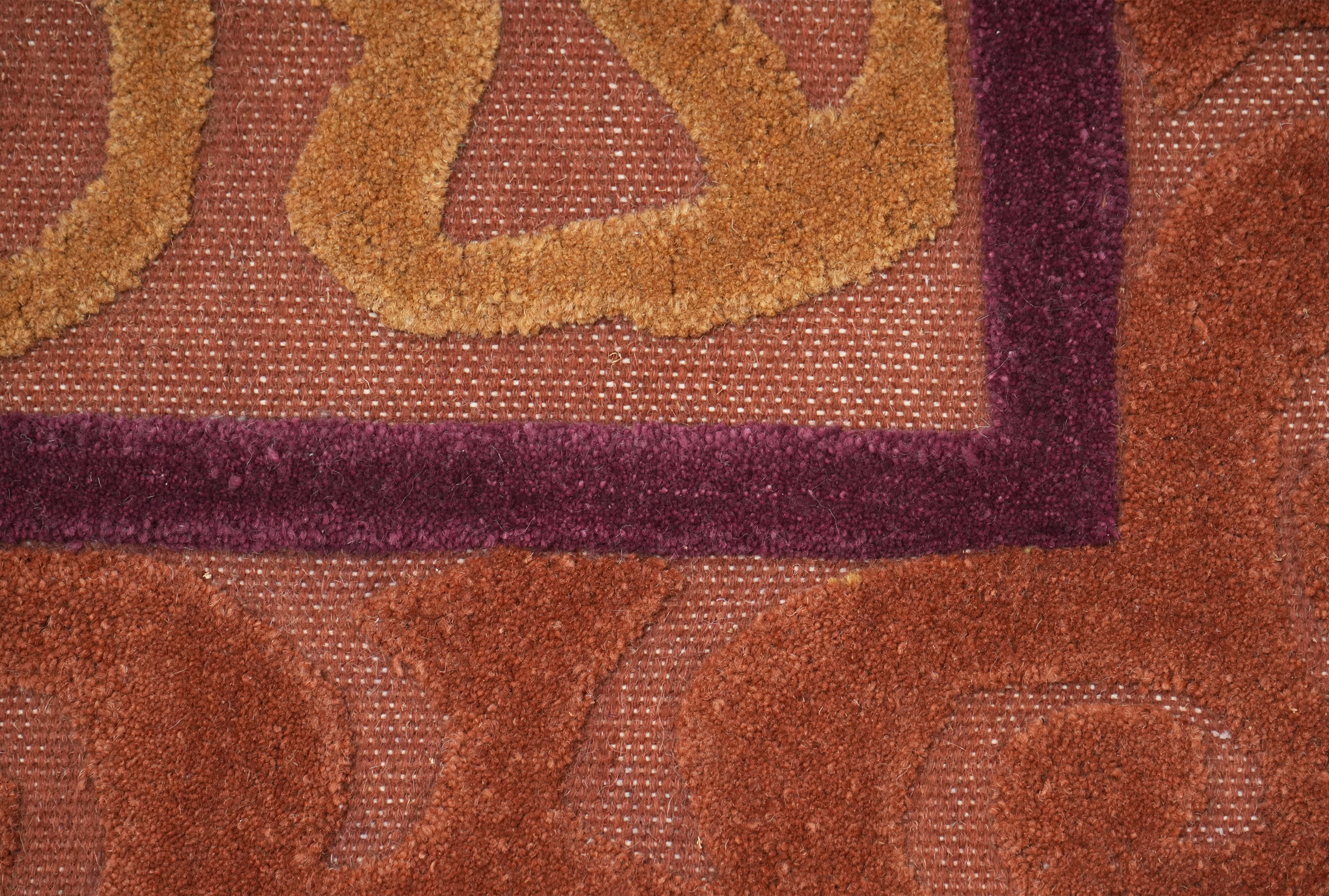 Saffron Dynasty rug styled detail showing rich saffron and deep plum border