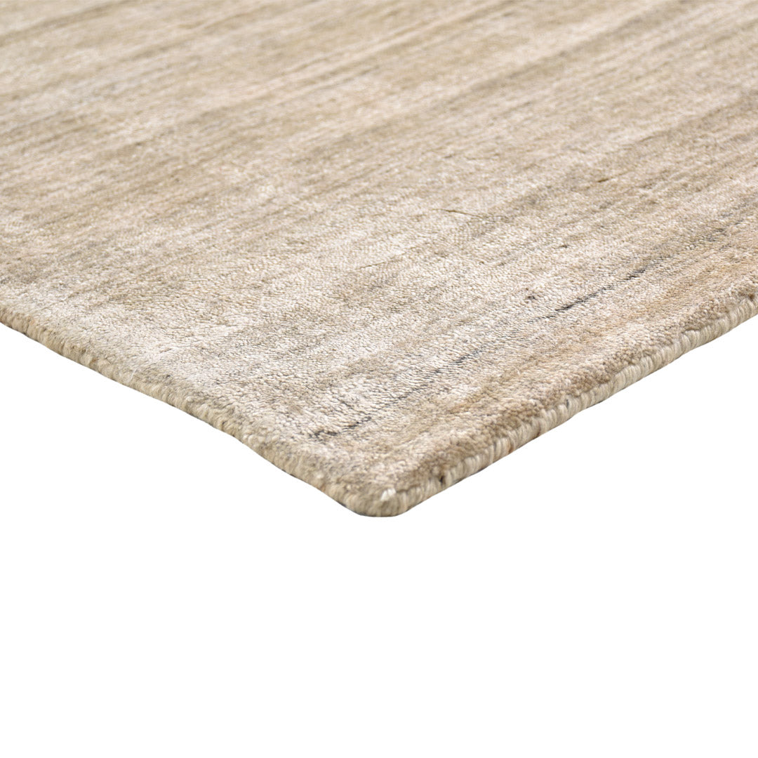 sand dune handloom textured rug edge detail on white background