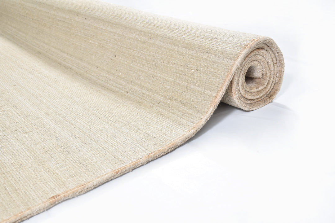 sand dune handloom textured rug rolled side view on white background