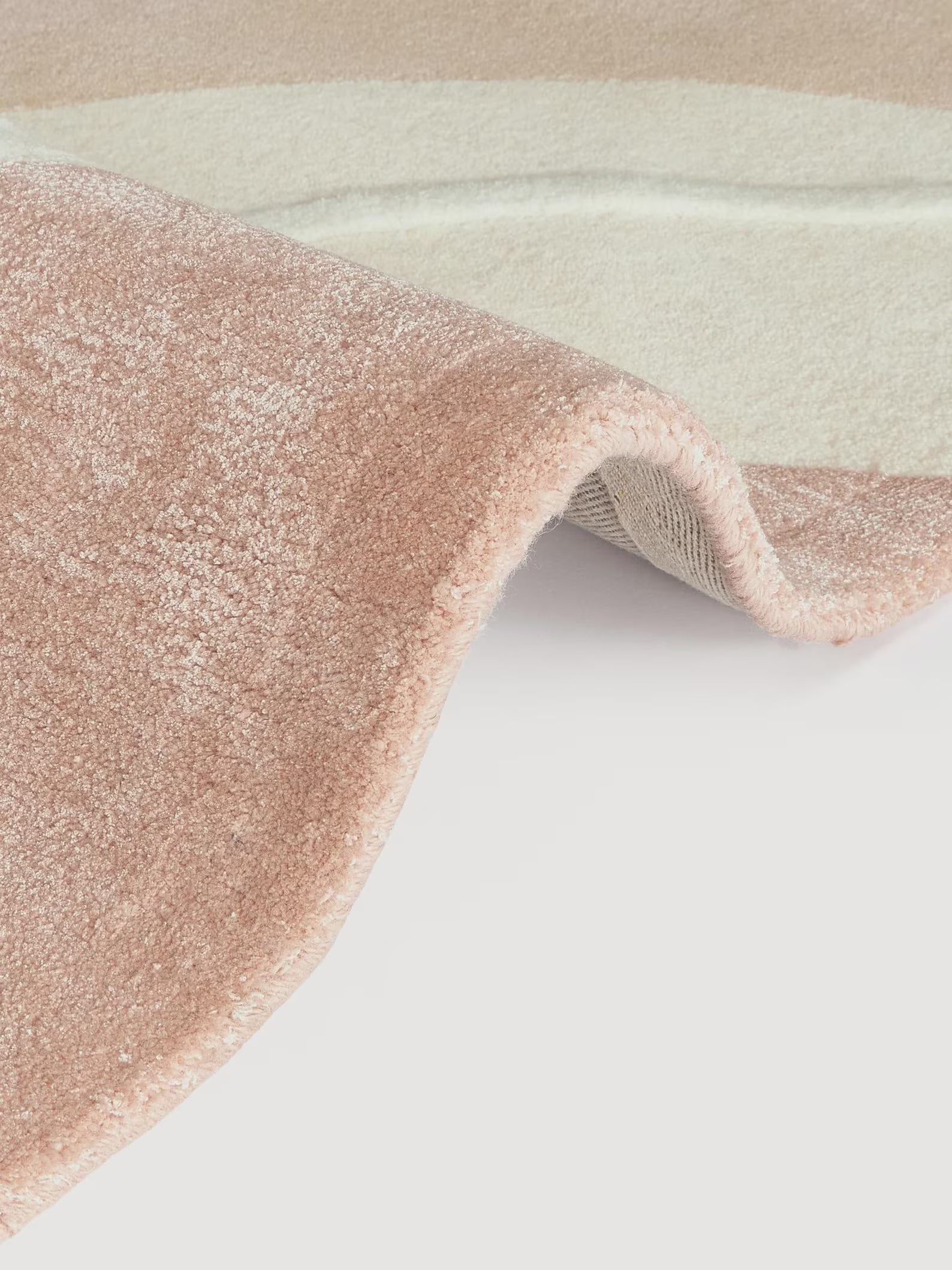 Seren hand tufted rug folded texture view showing smooth wool surface and gentle curved design