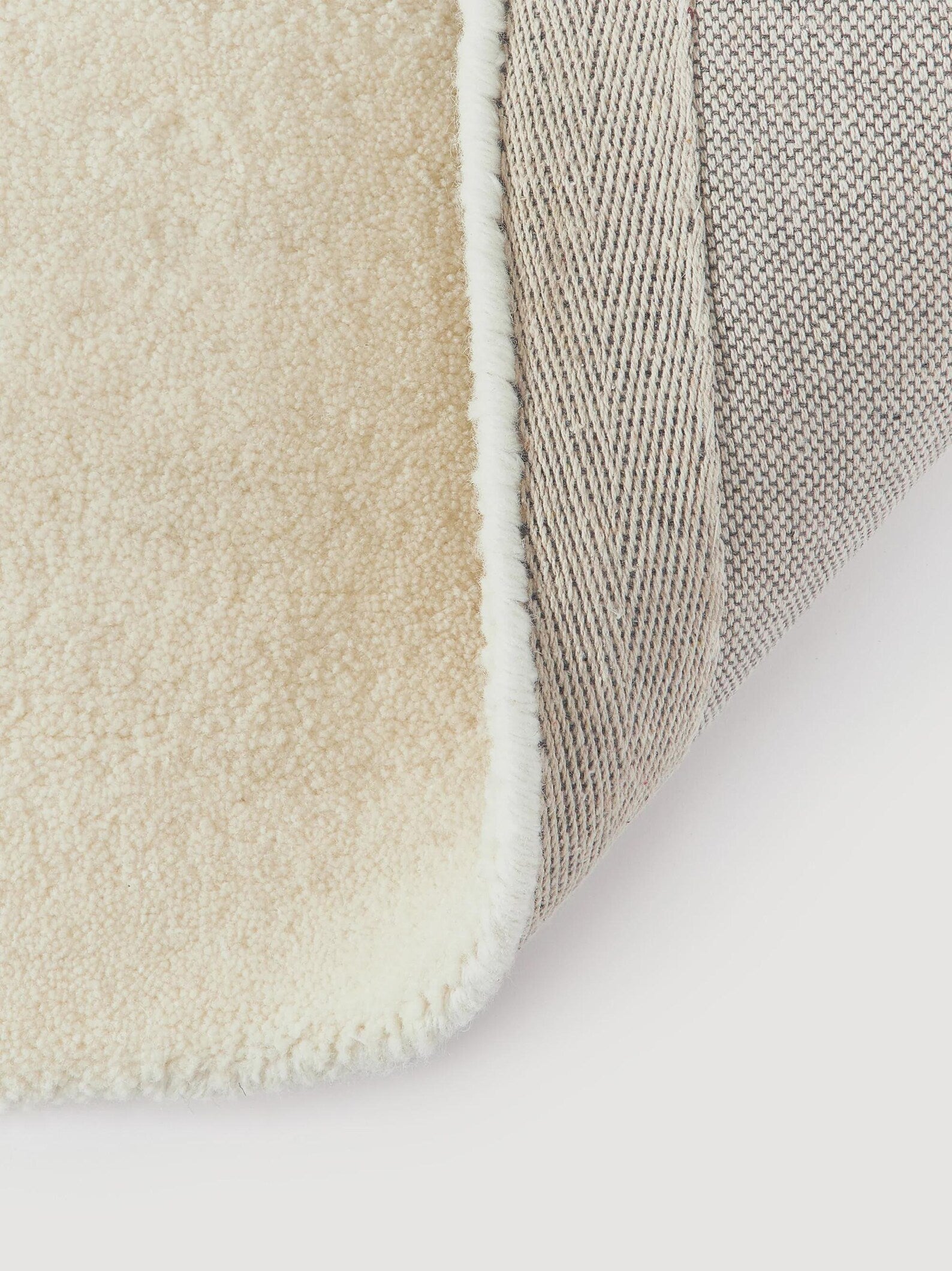 Seren Rug backing view showing tightly woven base and soft cream wool pile