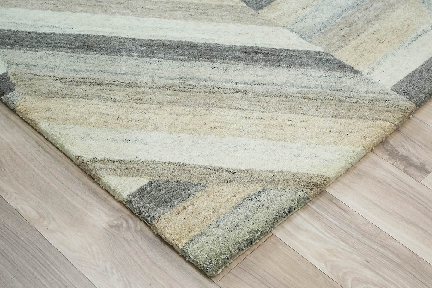 corner detail of Strata Shift Rug highlighting hand tufted texture and diagonal pattern