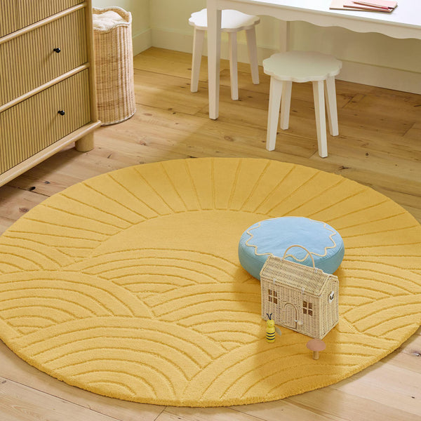 Sunrise Serenity Rug styled in a cozy kids room with round shape and soft yellow tone