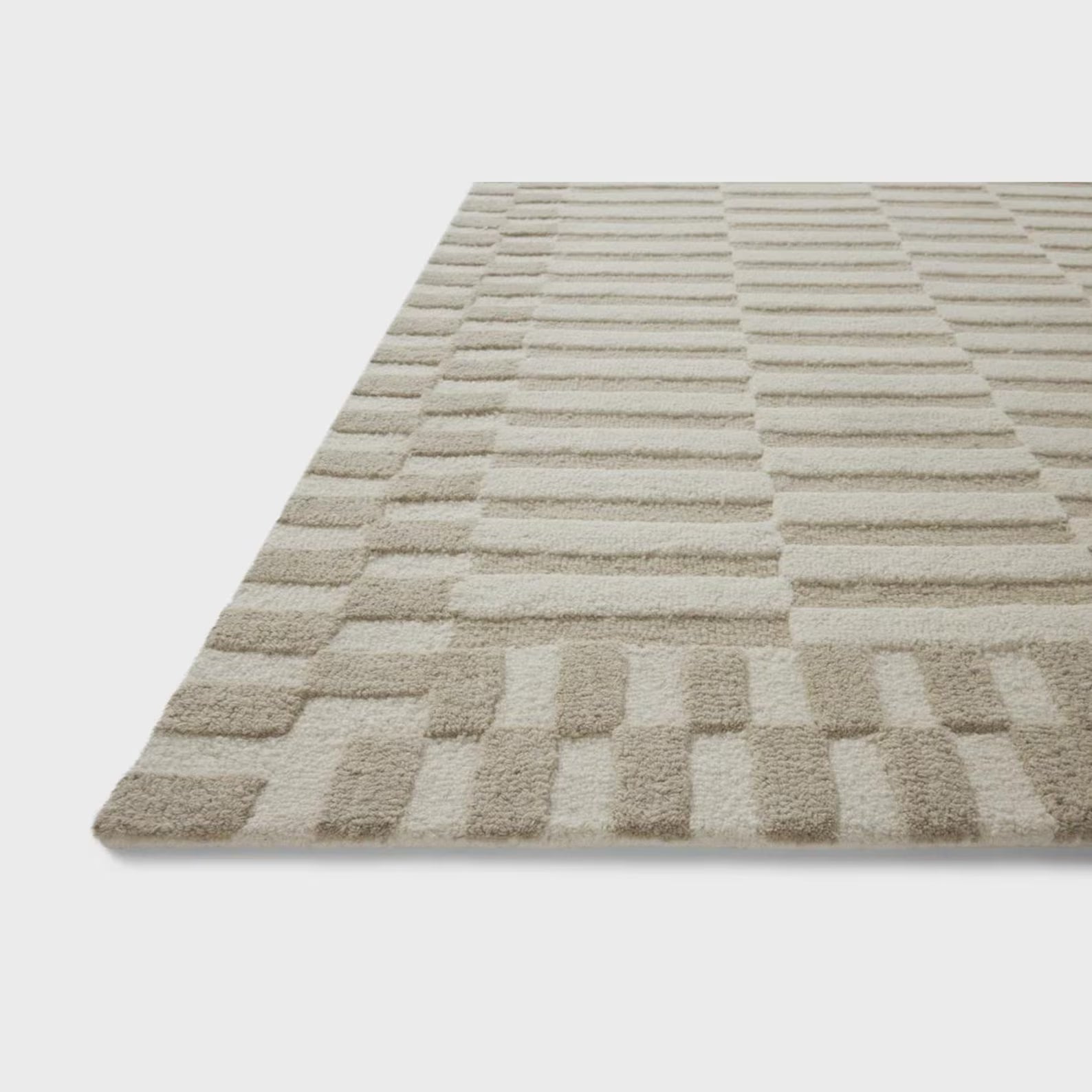 Tactile Grid Rug angled view showing carved geometric grid texture and soft neutral tone