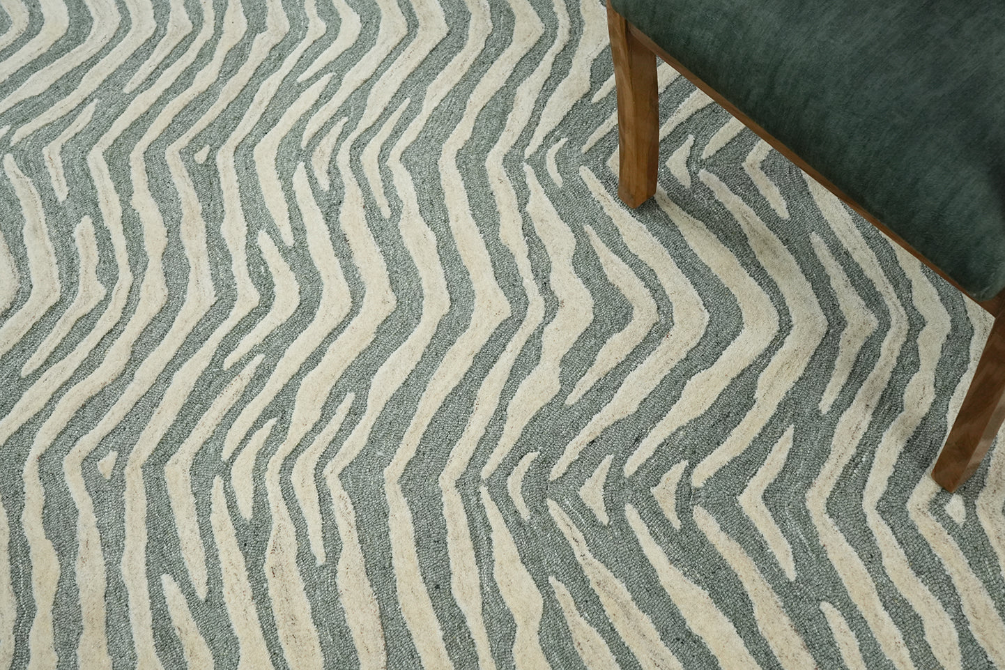 Tide Wool Rug hand tufted from premium wool shown in an interior setting with furniture, highlighting the flowing wave pattern and floor placement