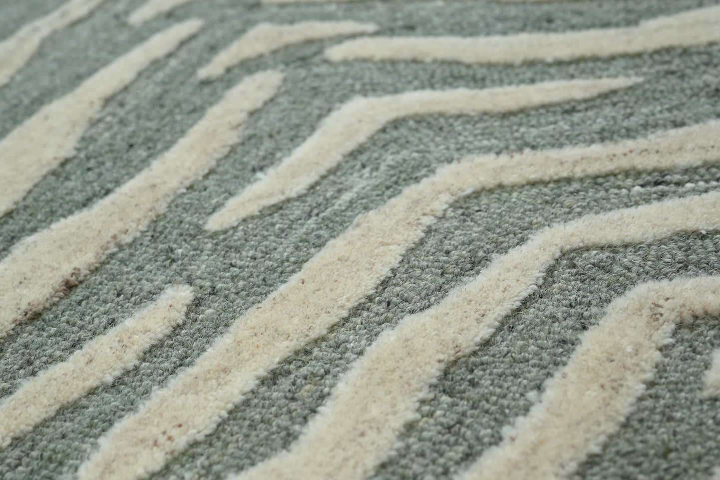 Close-up texture view of Tide Wool Rug hand tufted from premium wool highlighting the raised wave pattern and surface detail
