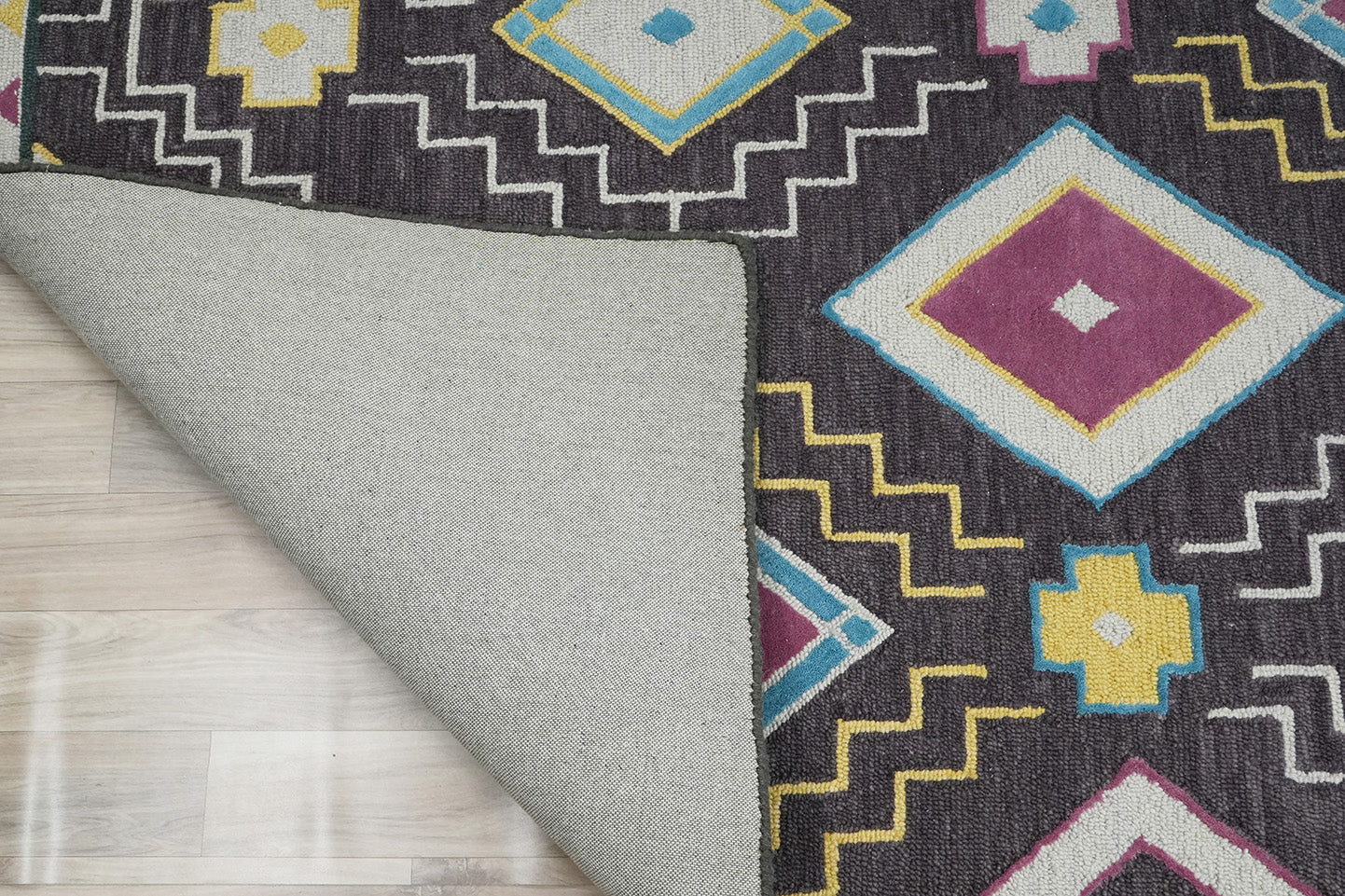 Folded corner detail of Tribal Geometry Wool Rug highlighting hand tufted wool pile and backing finish