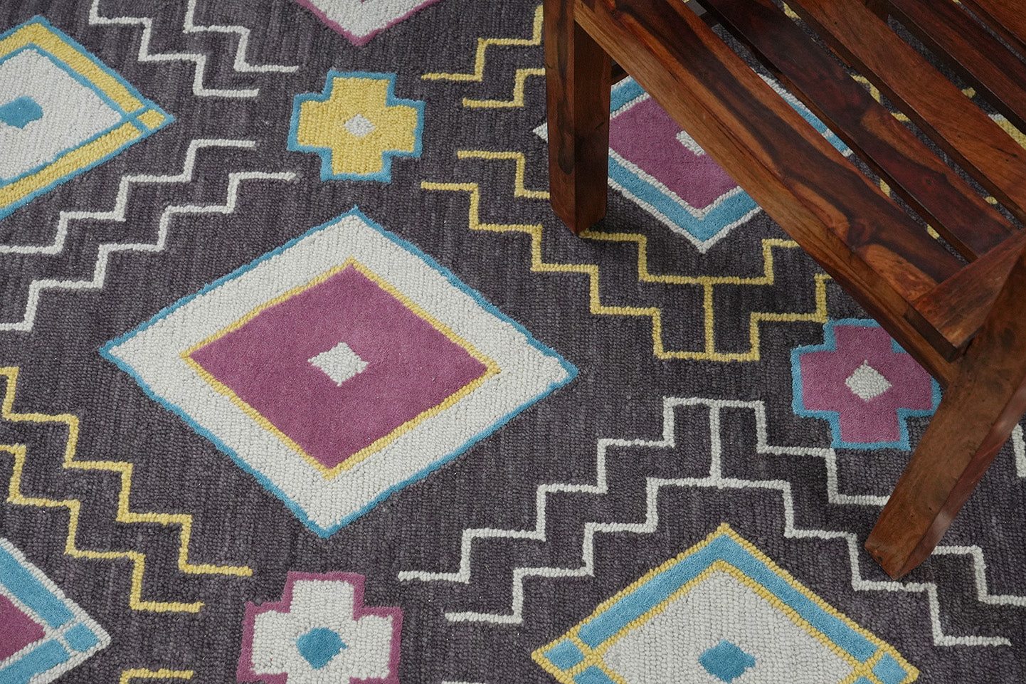 Tribal Geometry Wool Rug hand tufted from wool styled in a living room showing bold geometric tribal patterns under furniture
